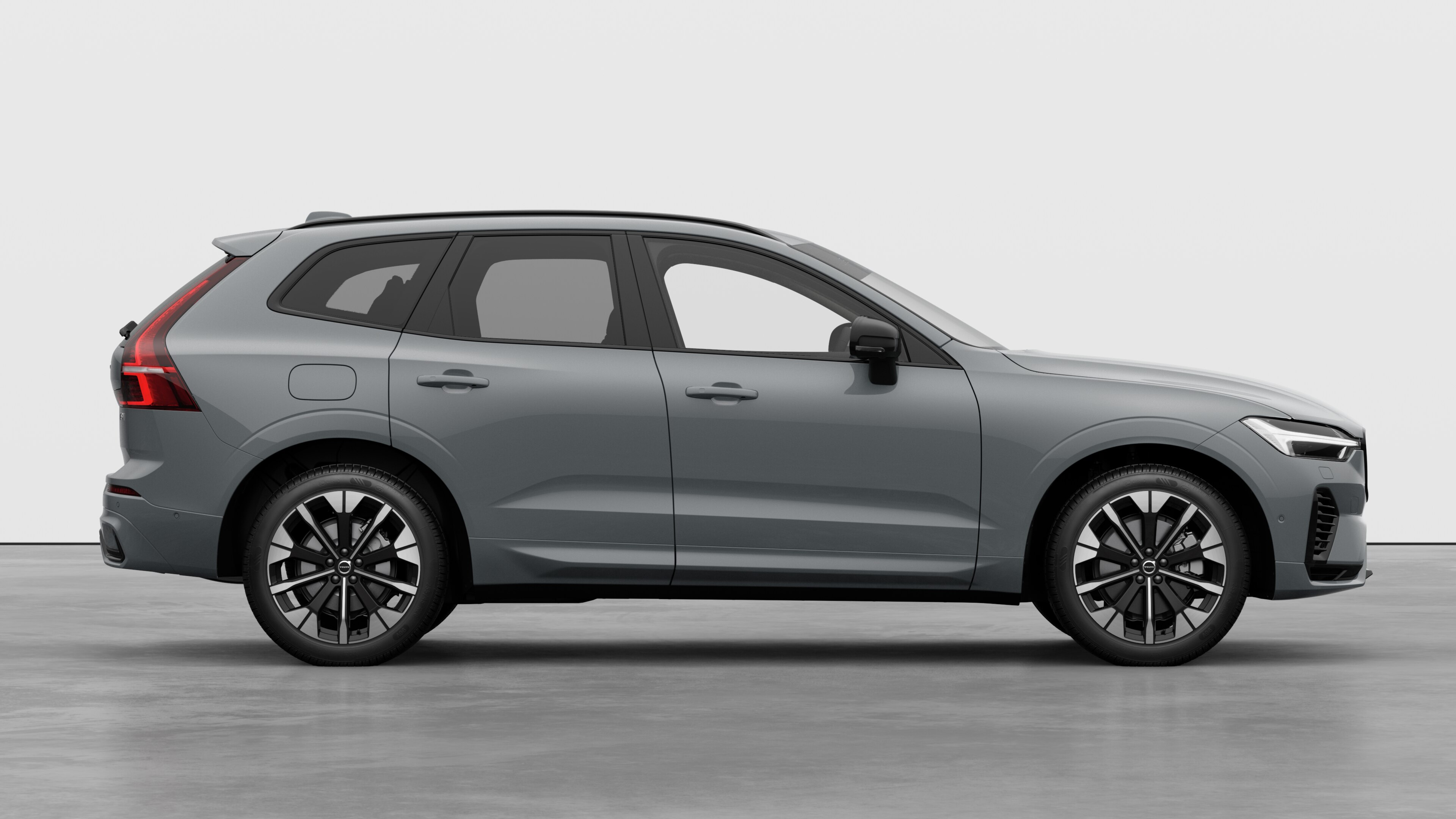 Volvo car side view on plain studio background displaying closed doors and visible wheel design.