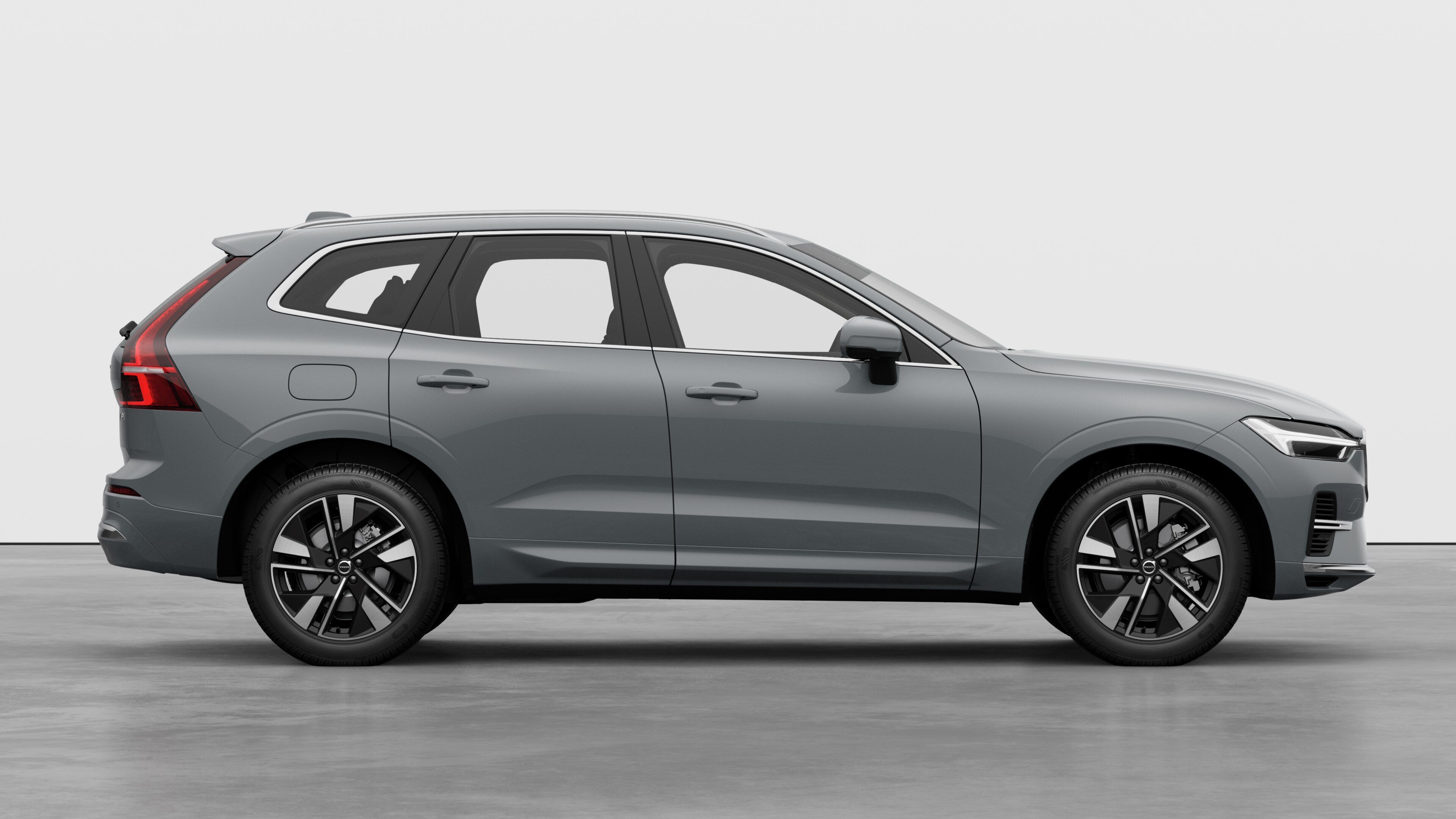 Страничен изглед на автомобил Volvo на обикновен студиен фон, показващ затворени врати и видим дизайн на колелата.