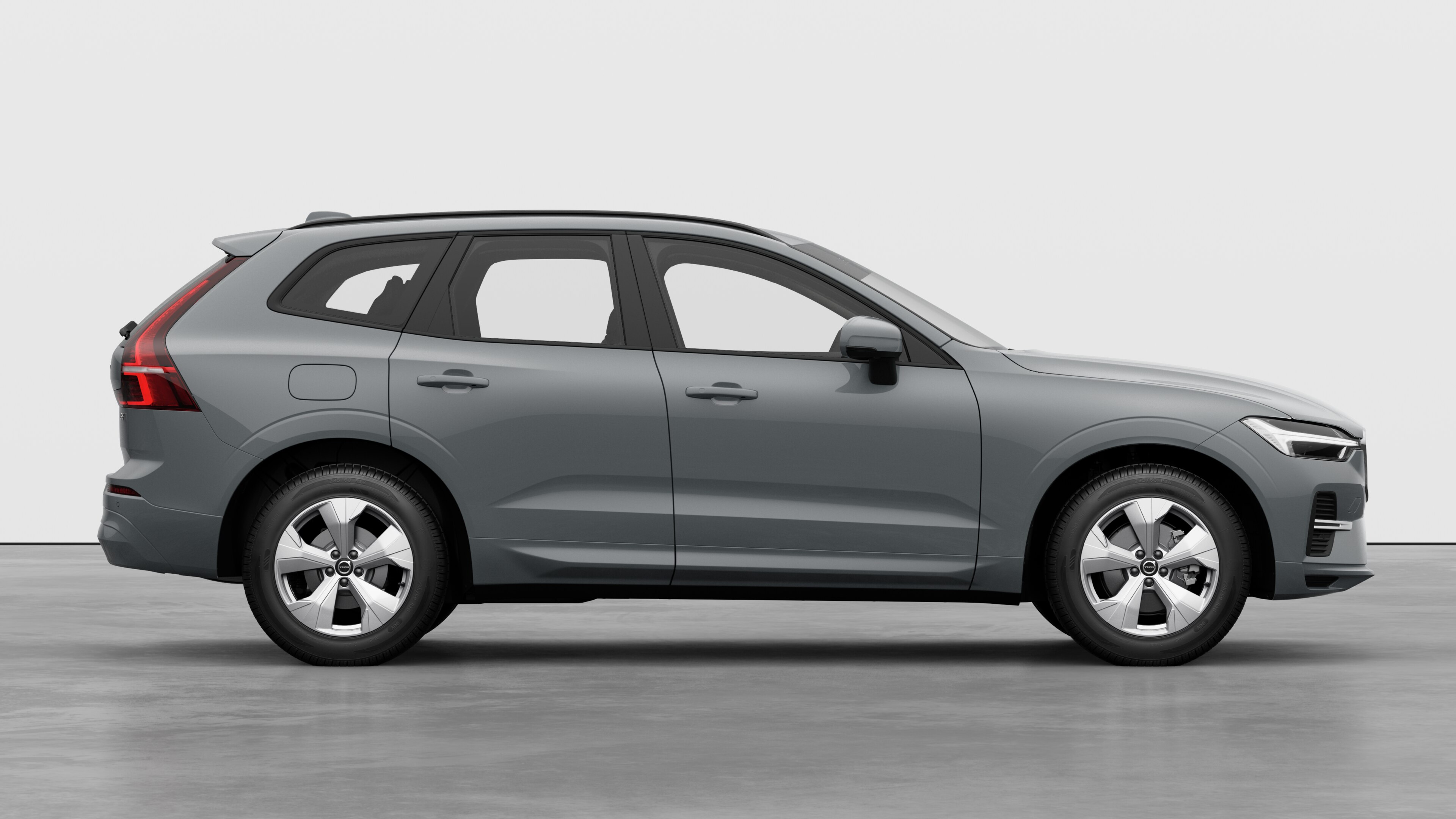 Страничен изглед на автомобил Volvo на обикновен студиен фон, показващ затворени врати и видим дизайн на колелата.