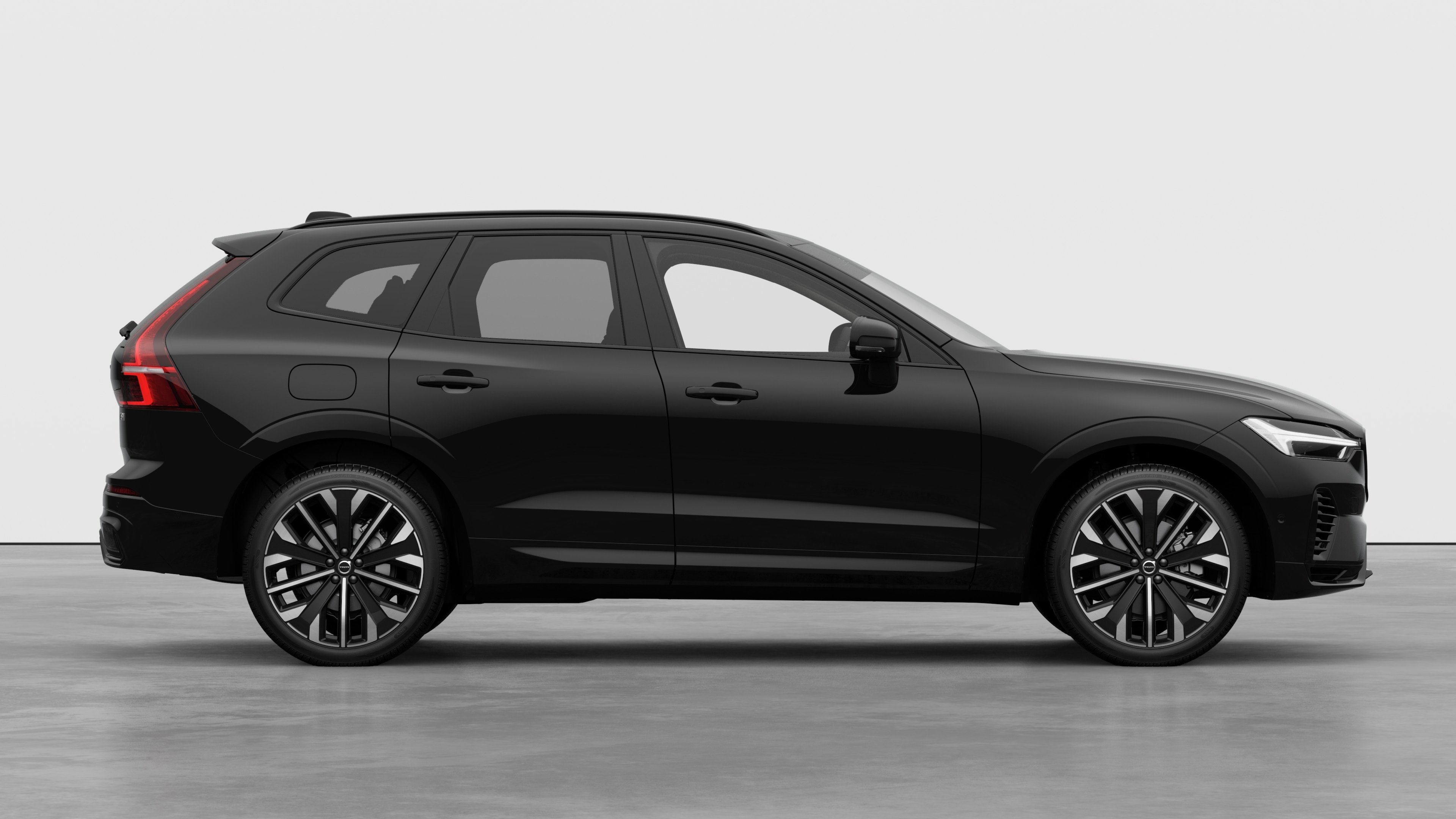 Volvo car side view on plain studio background displaying closed doors and visible wheel design.