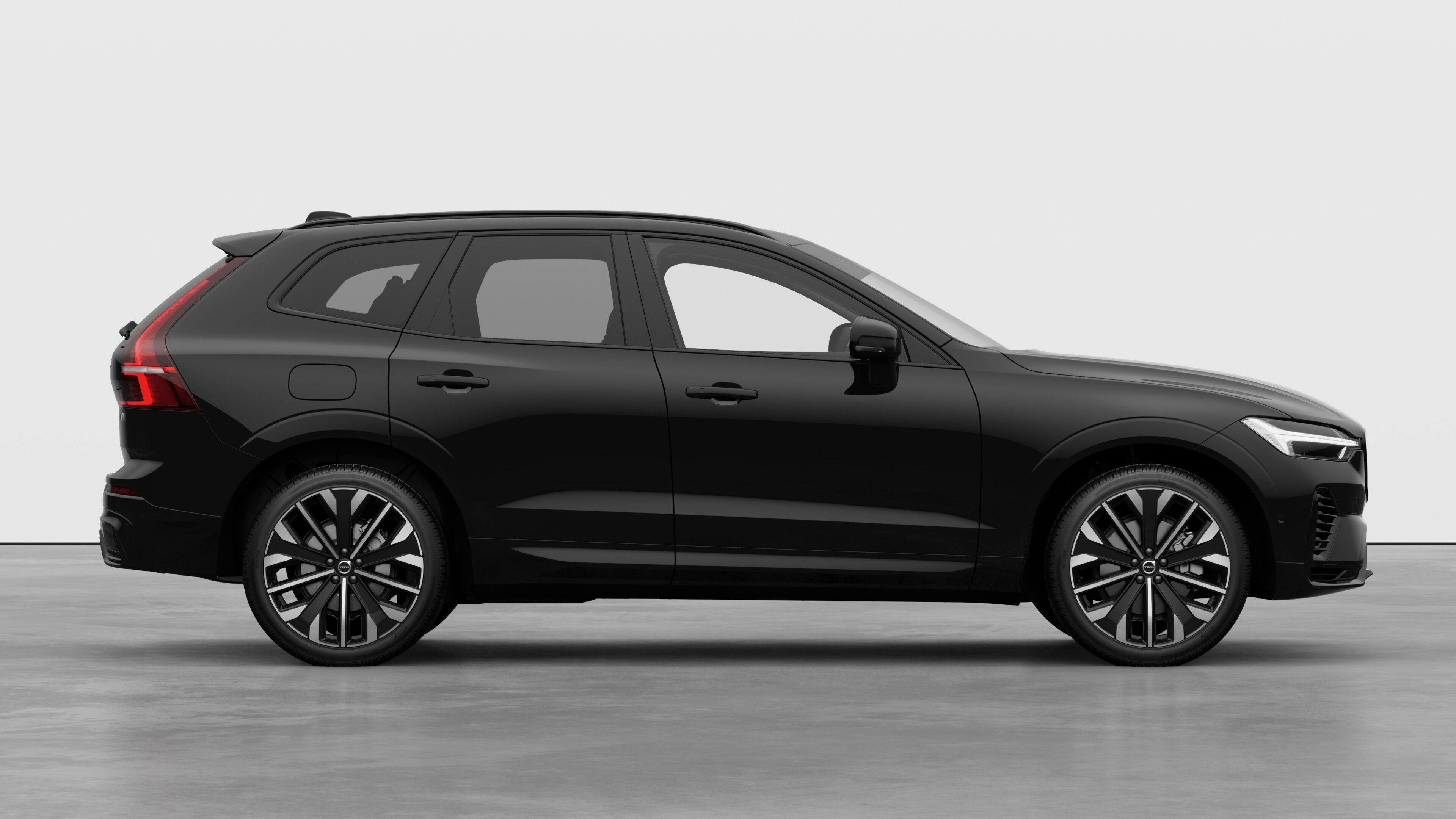 Volvo car side view on plain studio background displaying closed doors and visible wheel design.