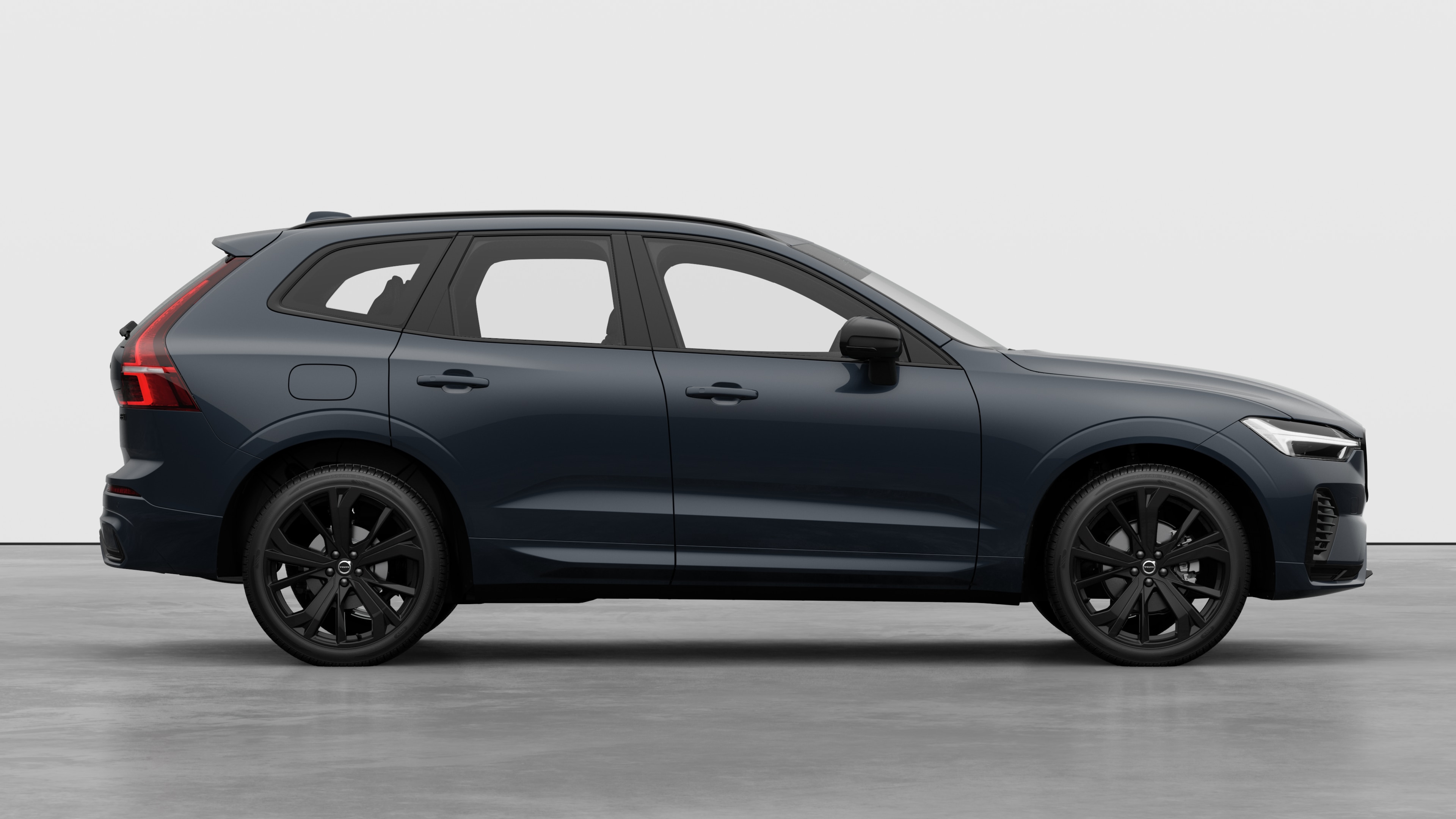 Seitenansicht eines Volvo Fahrzeugs auf einem schlichten Studiohintergrund mit geschlossenen Türen und sichtbarem Raddesign.