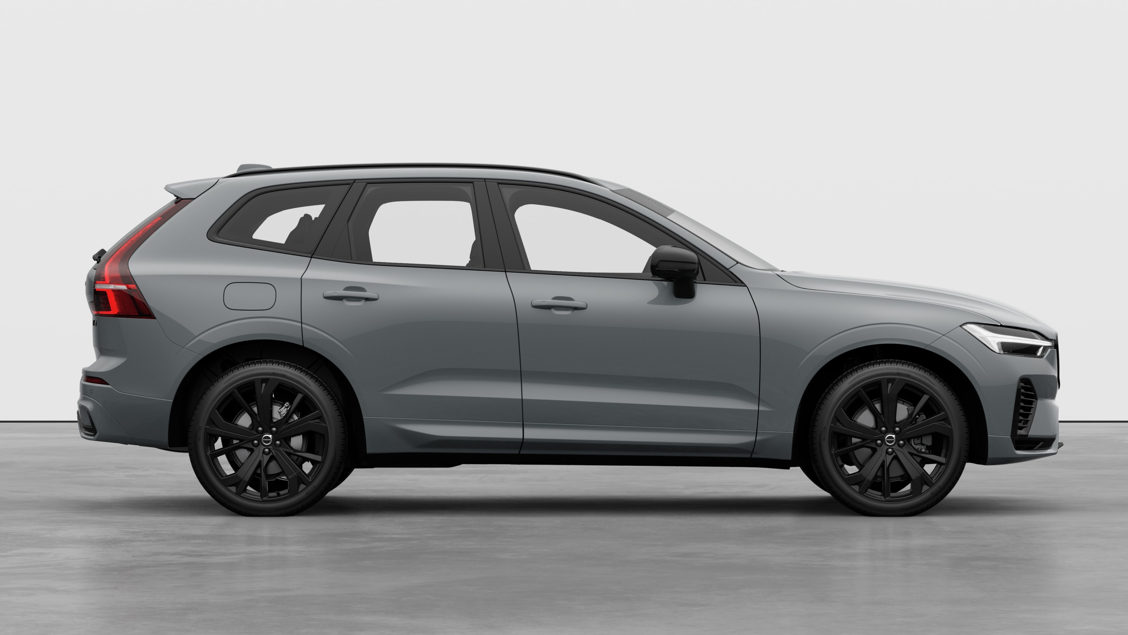 Seitenansicht eines Volvo Fahrzeugs auf einem schlichten Studiohintergrund mit geschlossenen Türen und sichtbarem Raddesign.