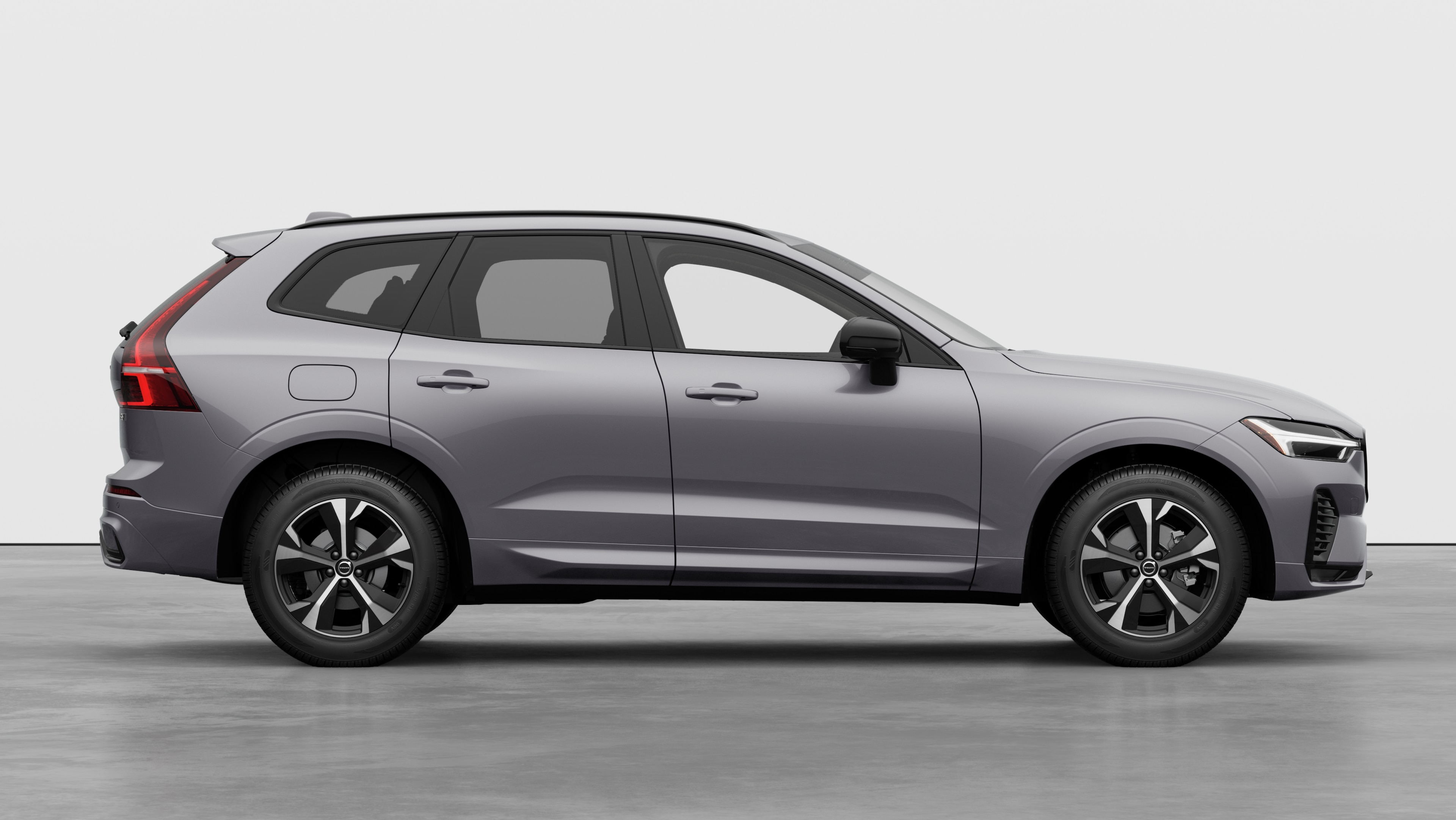 Volvo car side view on plain studio background displaying closed doors and visible wheel design.