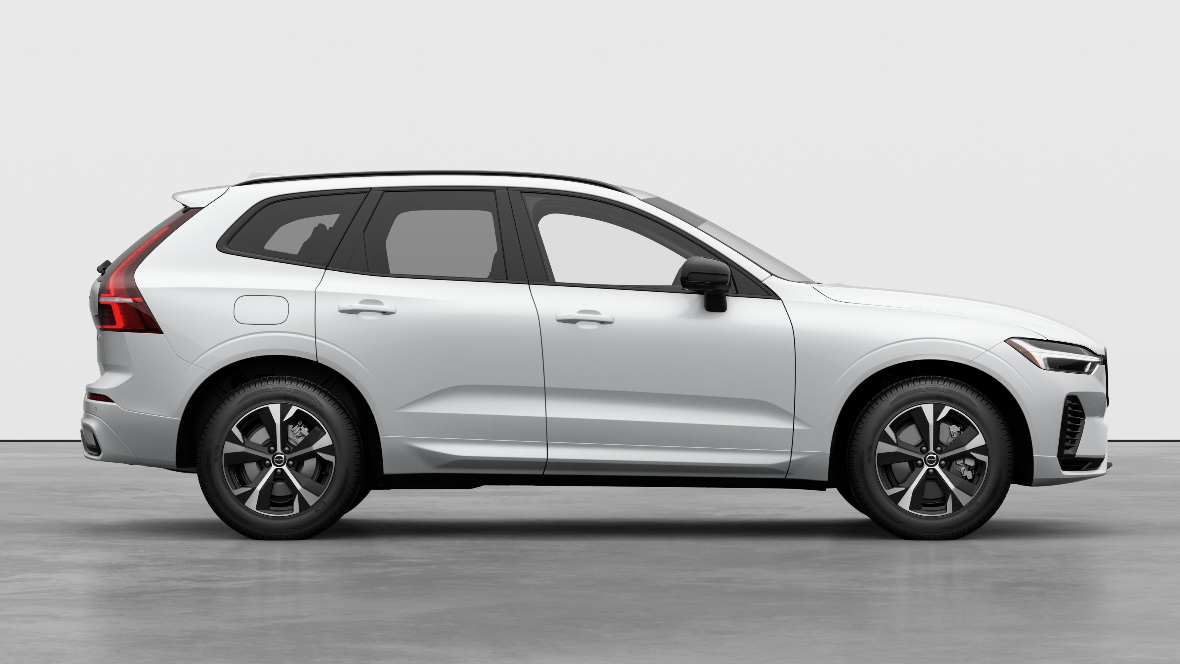 Volvo car side view on plain studio background displaying closed doors and visible wheel design.