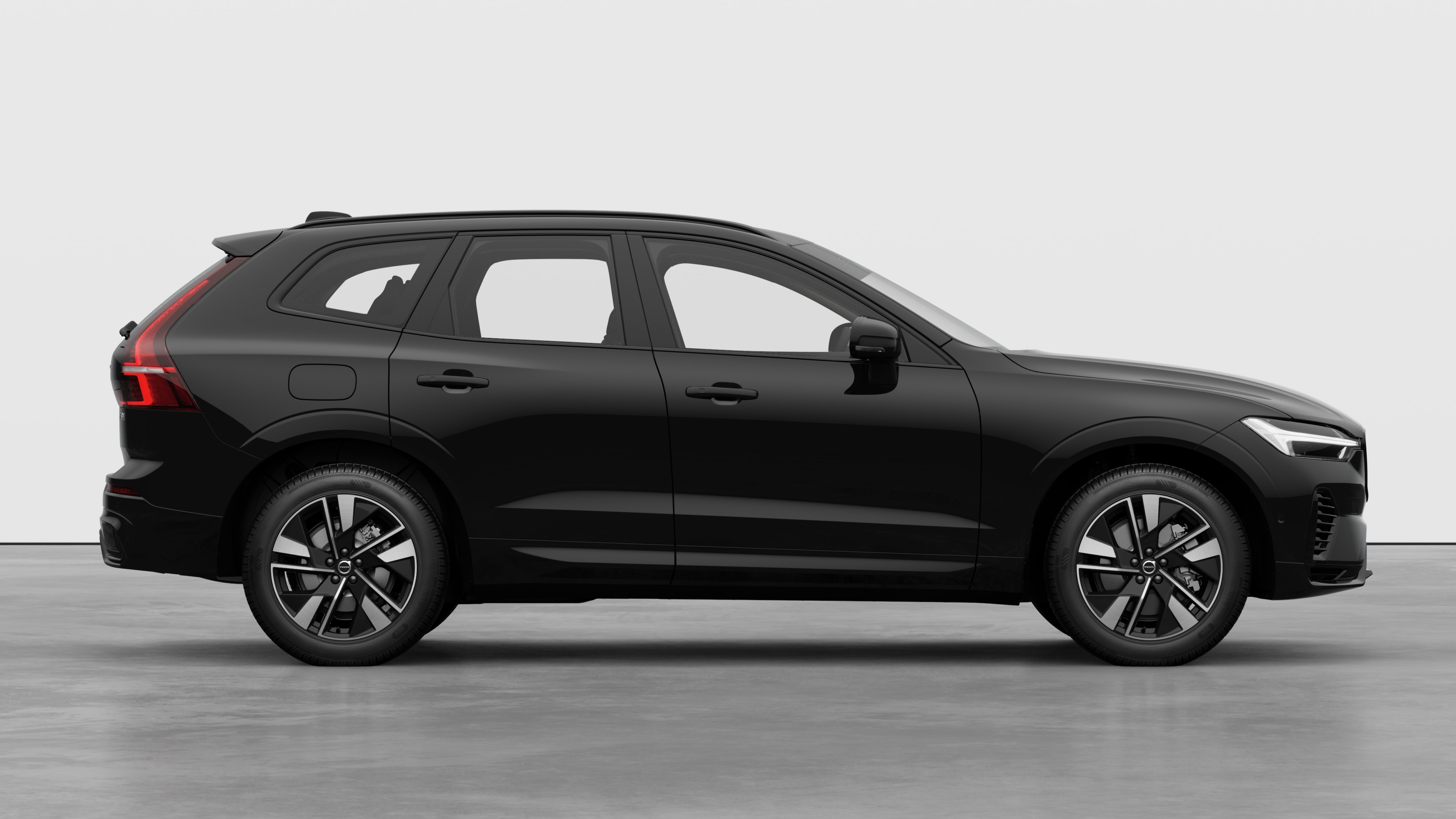 Volvo car side view on plain studio background displaying closed doors and visible wheel design.