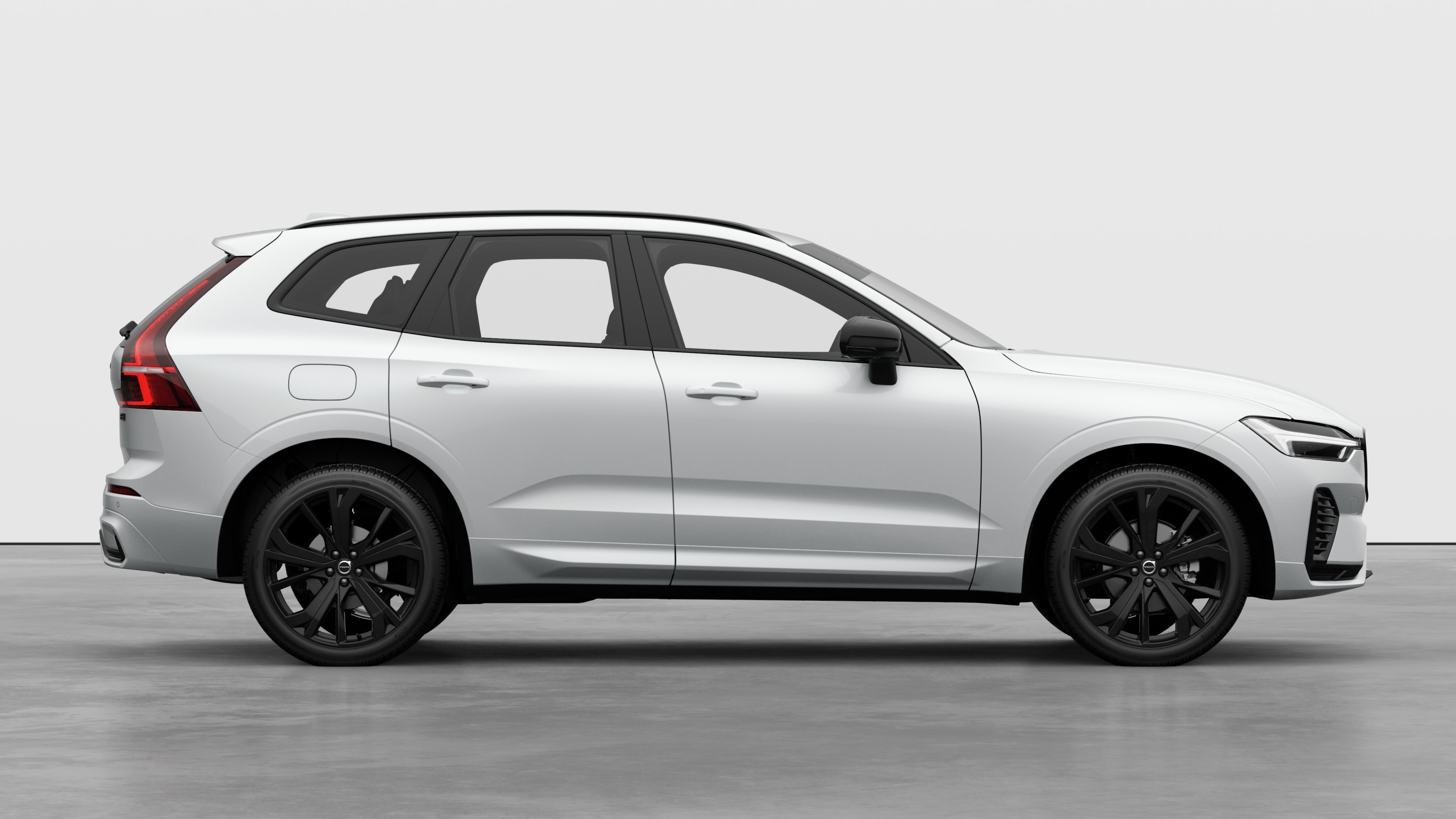 Seitenansicht eines Volvo Fahrzeugs auf einem schlichten Studiohintergrund mit geschlossenen Türen und sichtbarem Raddesign.