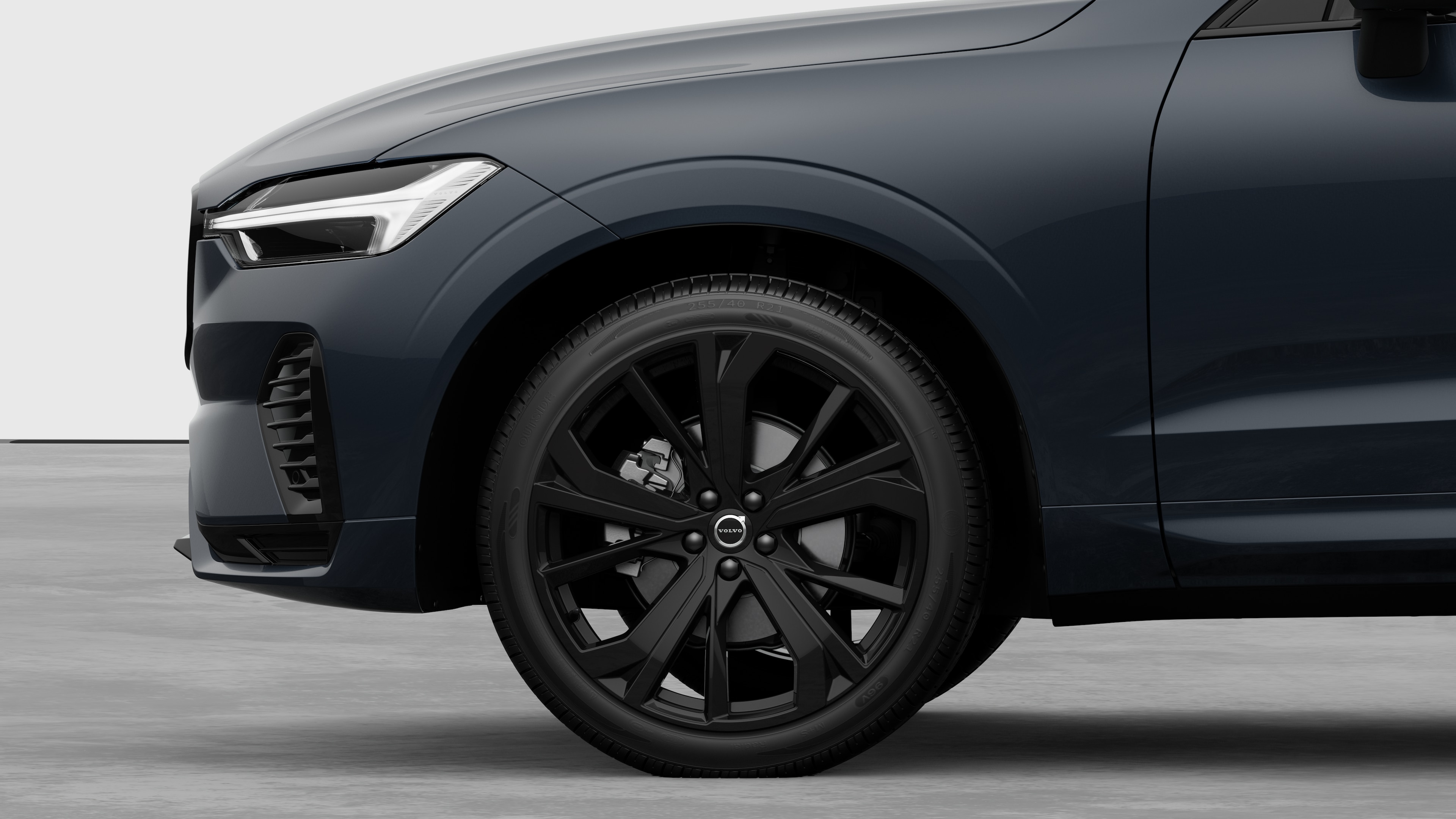 Seitenansicht eines Volvo Fahrzeugs mit Fokus auf Vorderrad und Kotflügel vor einem schlichten Studiohintergrund.