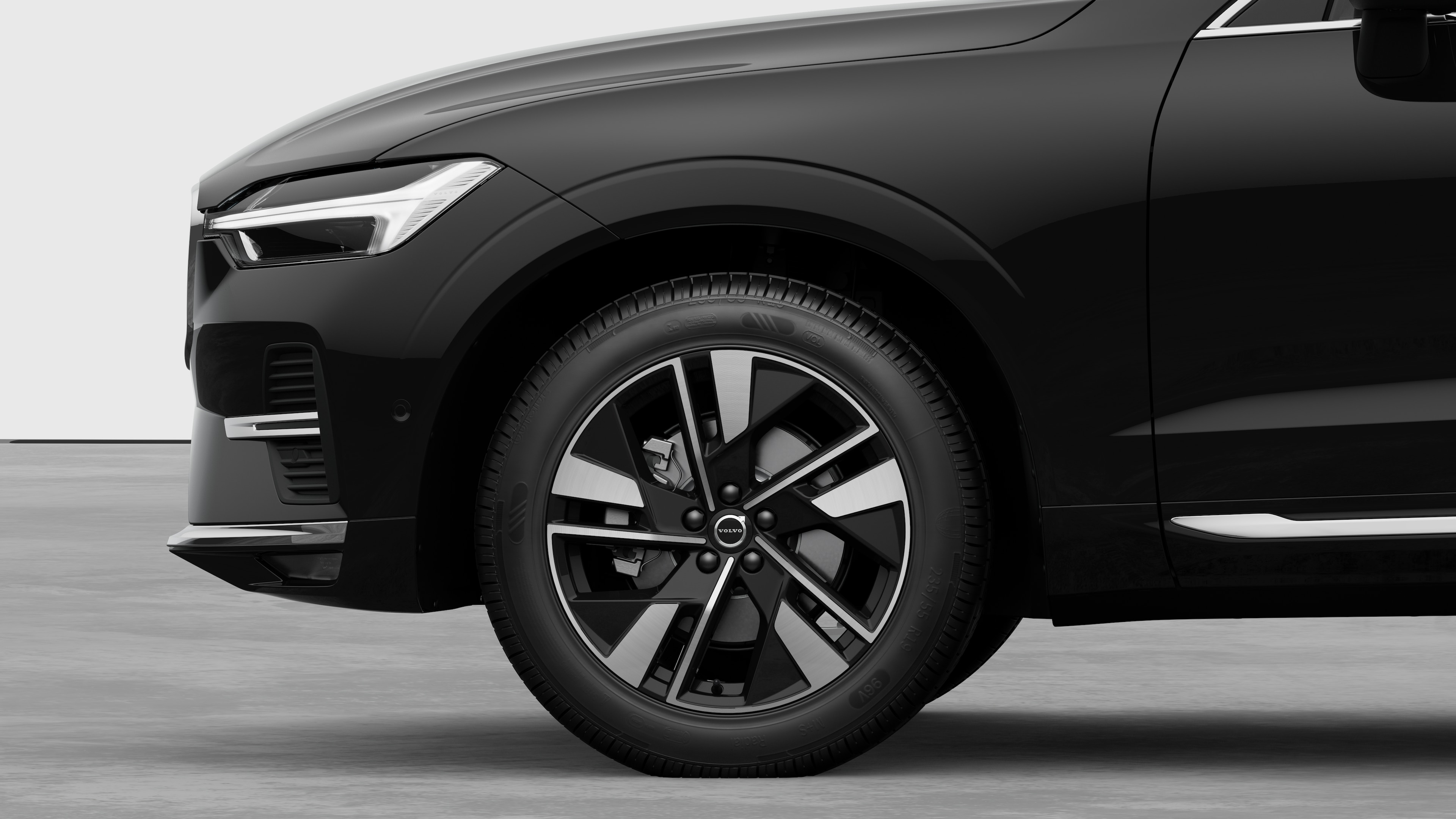 Hình ảnh bên ngoài xe Volvo tập trung vào bánh trước và chắn bùn, đặt trên nền studio đơn giản.