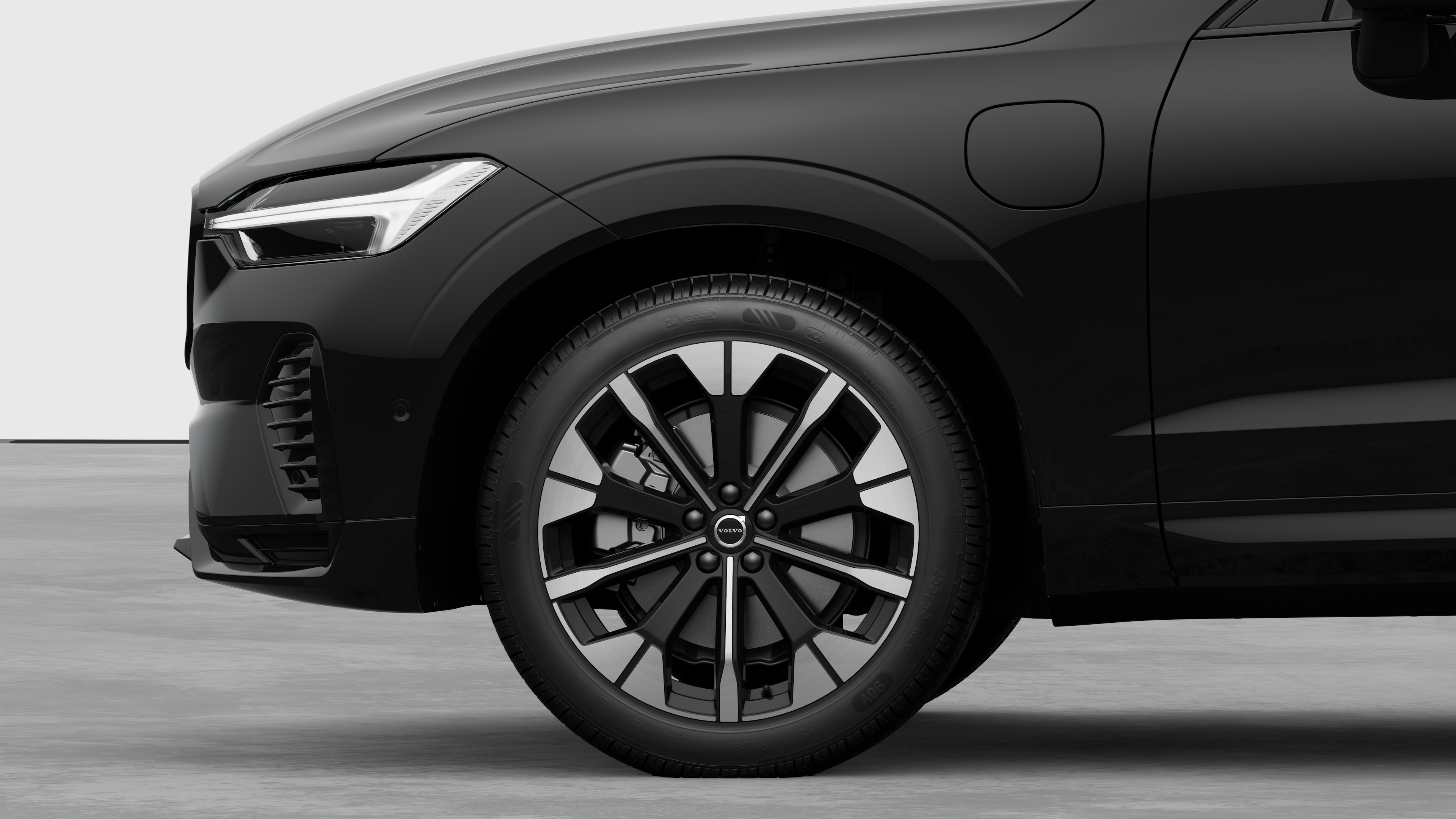 Volvo car exterior side view focusing on the front wheel and fender, set against a plain studio background.