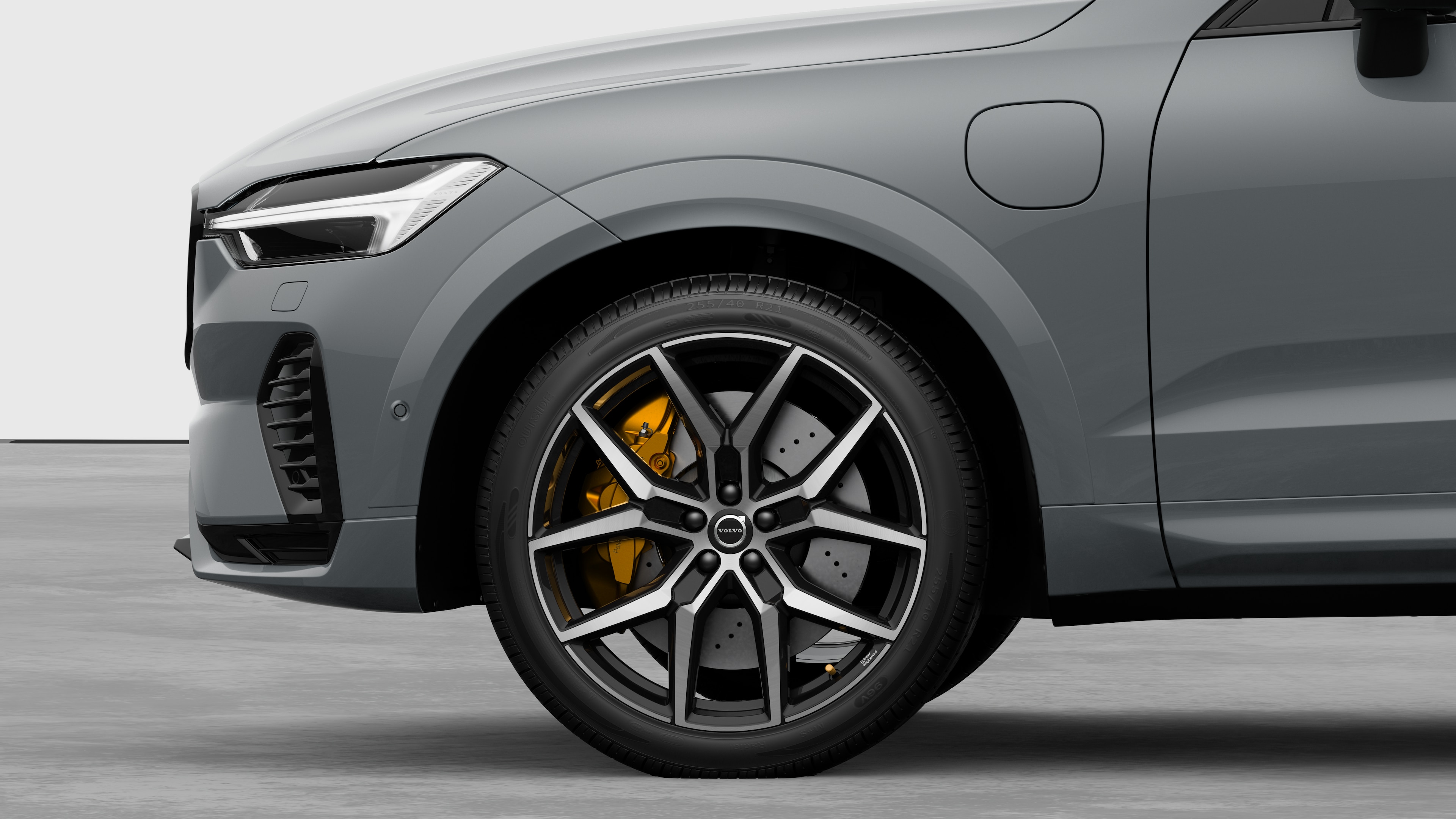 Volvo car exterior side view focusing on the front wheel and fender, set against a plain studio background.