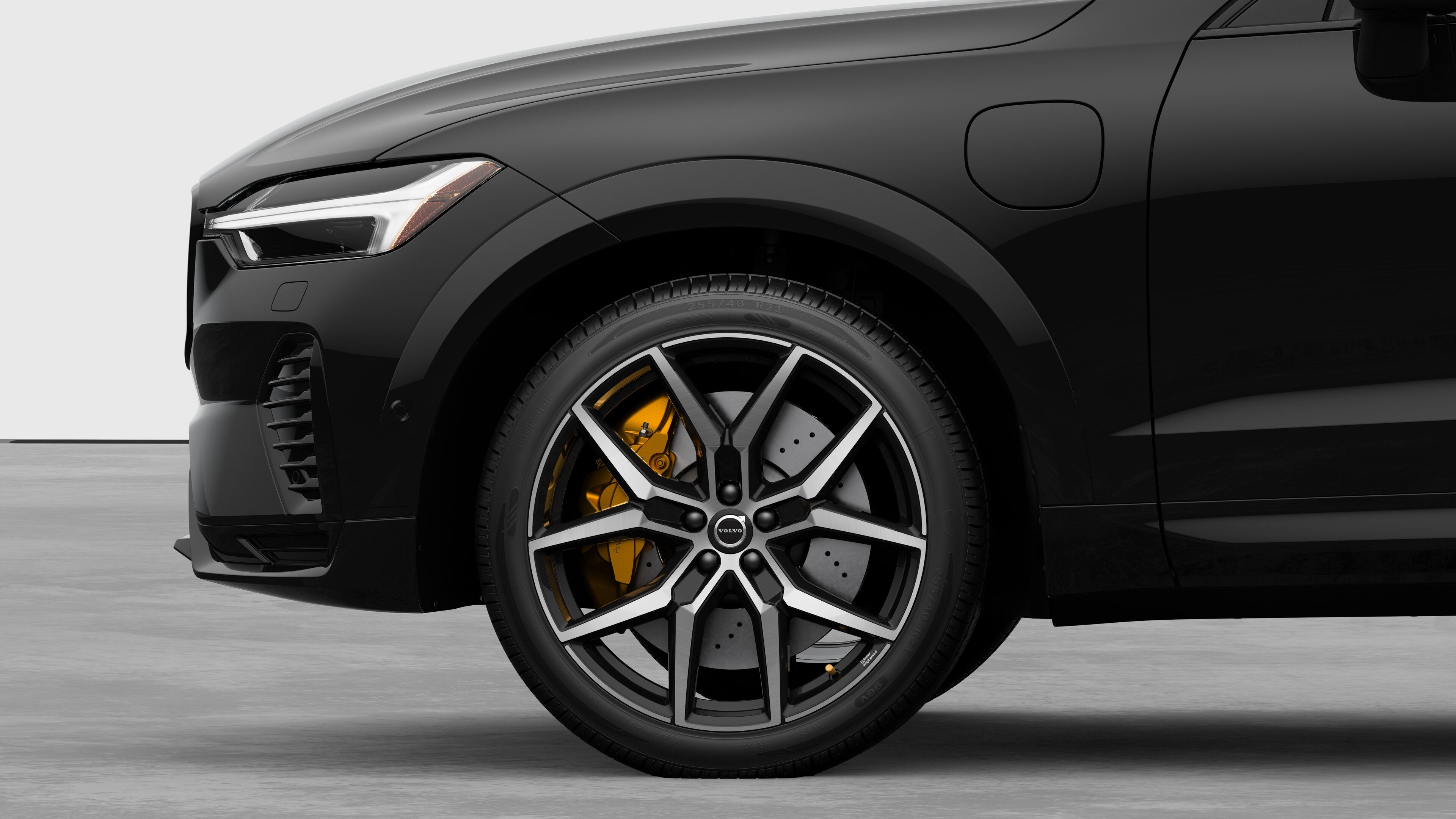 Volvo car exterior side view focusing on the front wheel and fender, set against a plain studio background.