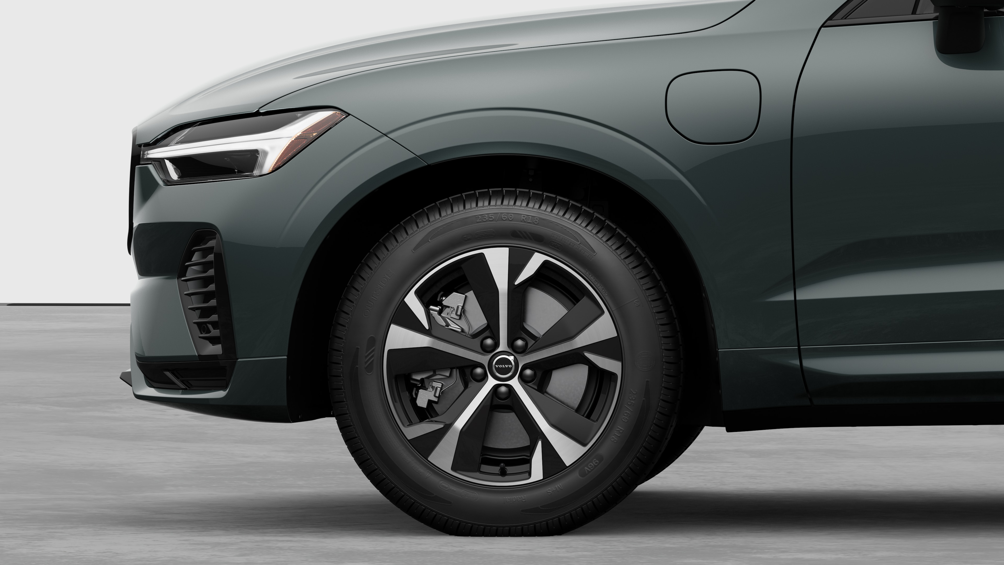 Volvo car exterior side view focusing on the front wheel and fender, set against a plain studio background.