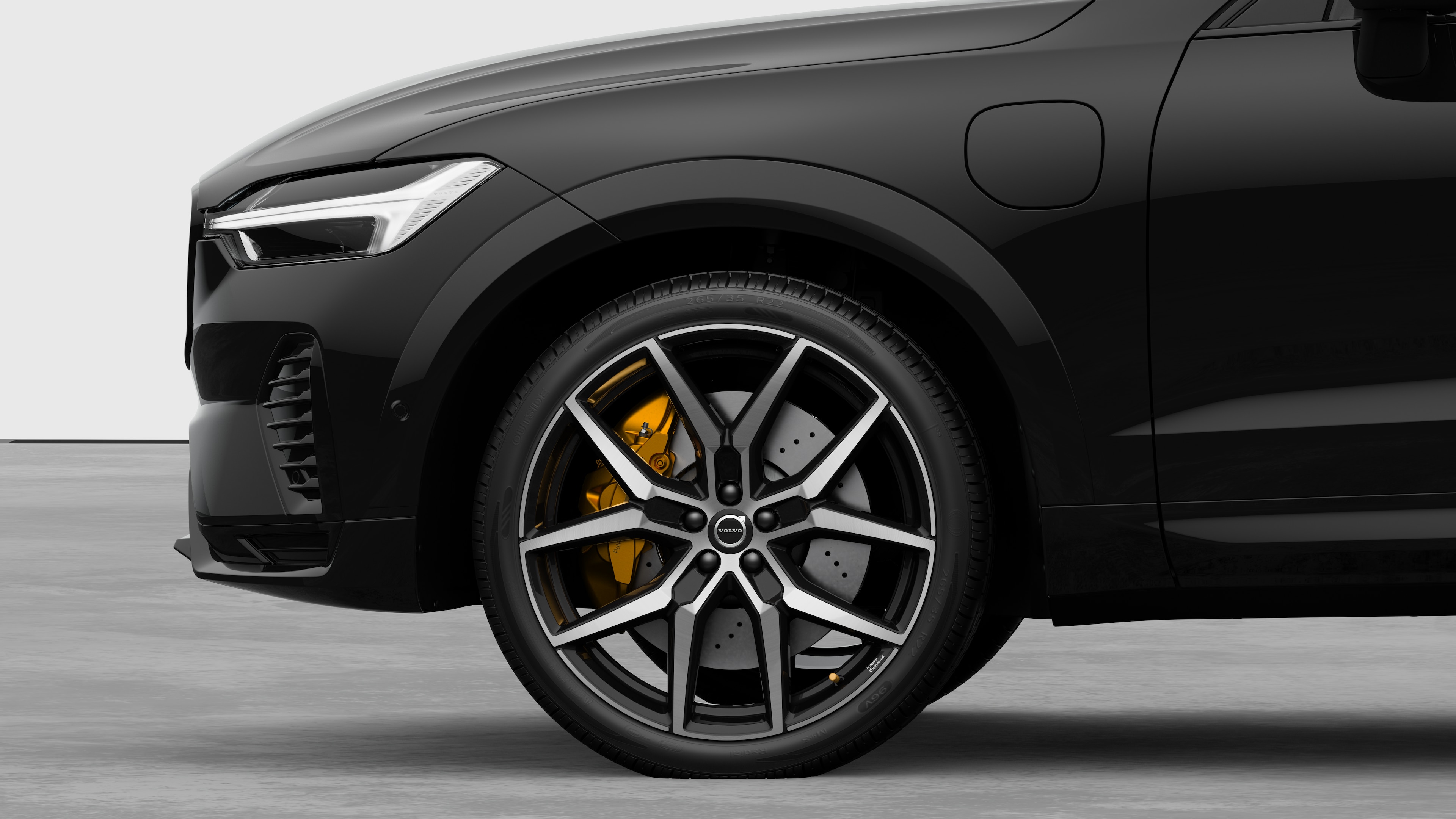 Volvo car exterior side view focusing on the front wheel and fender, set against a plain studio background.