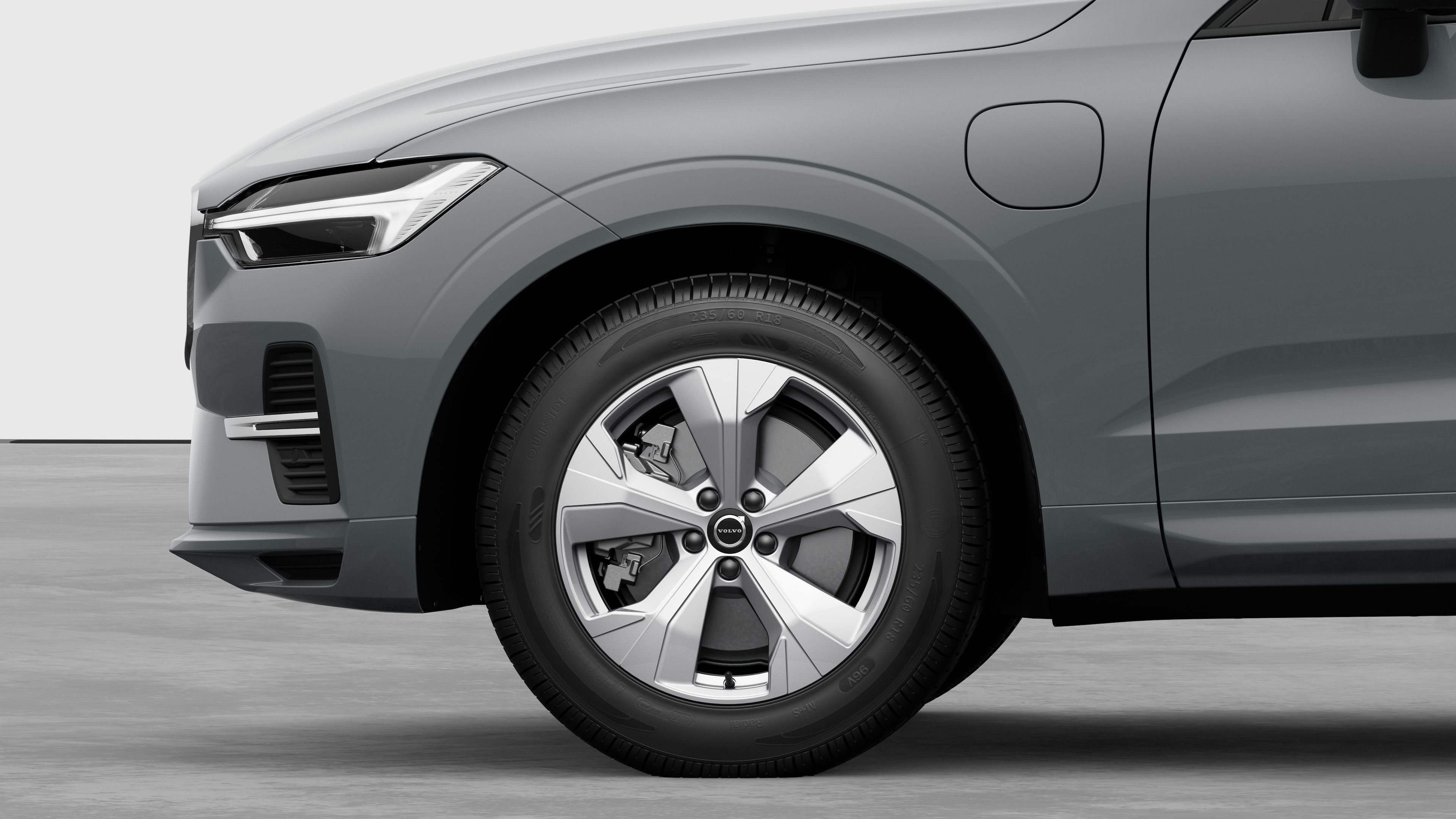 Volvo car exterior side view focusing on the front wheel and fender, set against a plain studio background.
