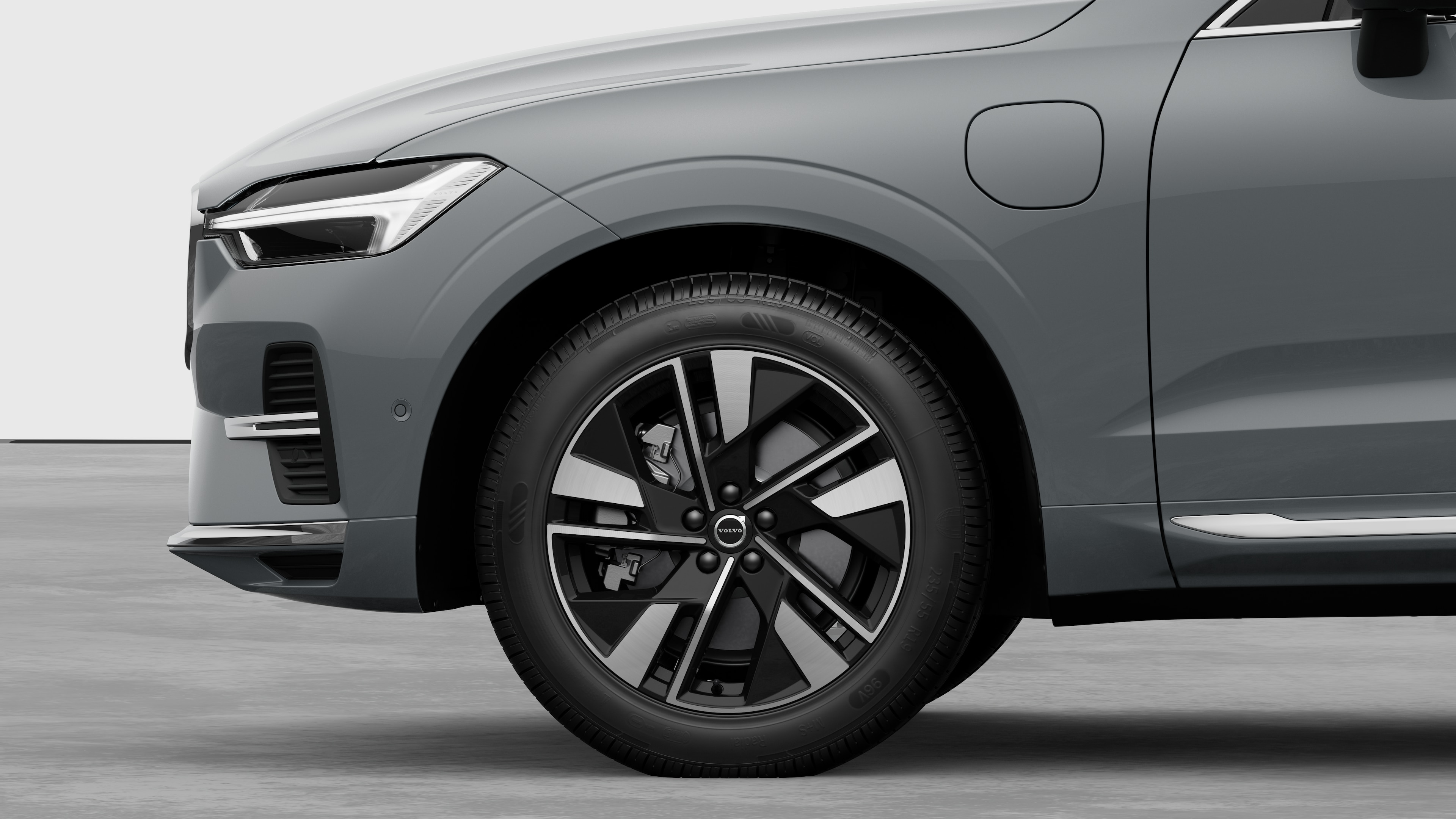 Volvo car exterior side view focusing on the front wheel and fender, set against a plain studio background.