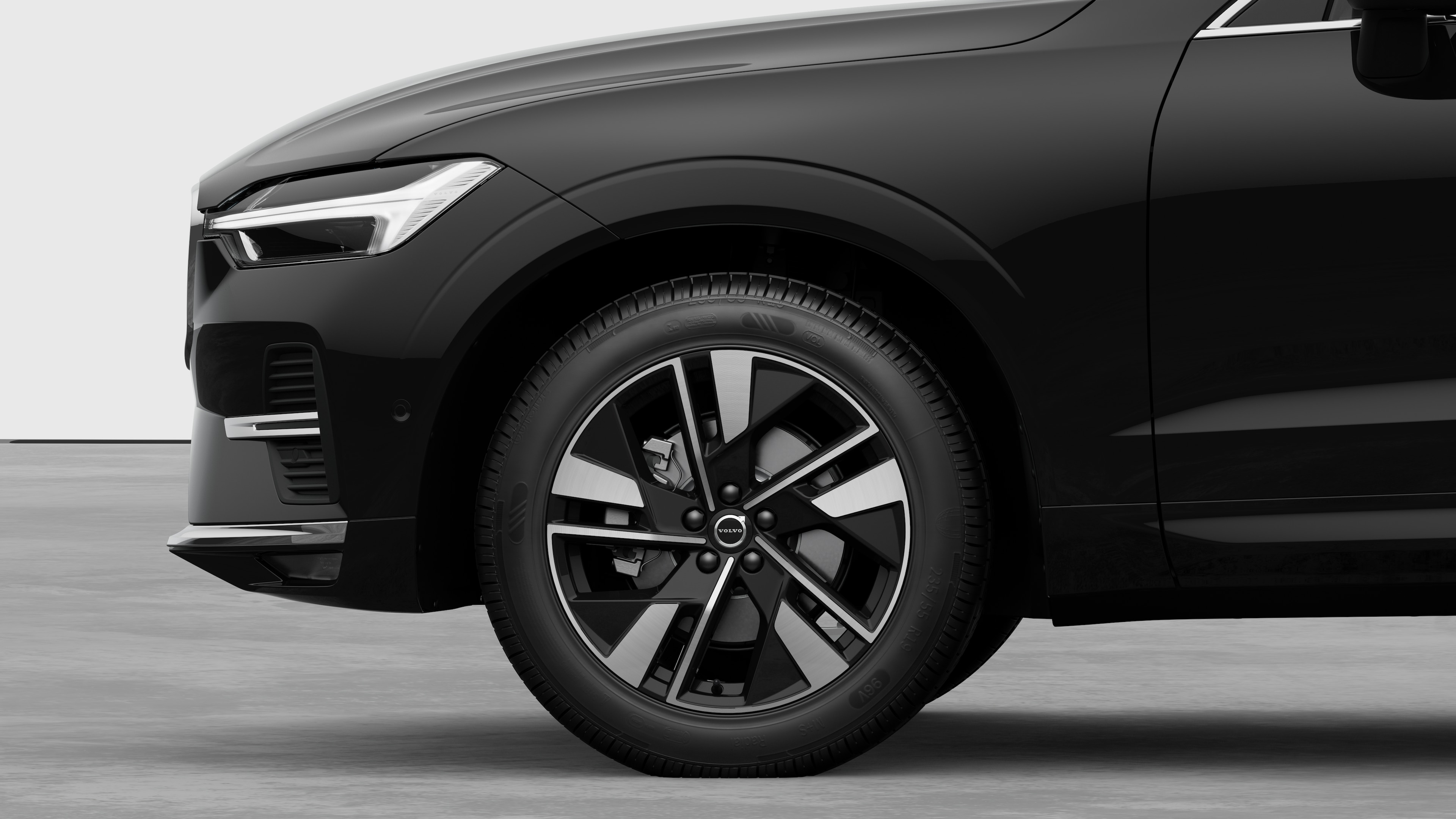 Volvo car exterior side view focusing on the front wheel and fender, set against a plain studio background.