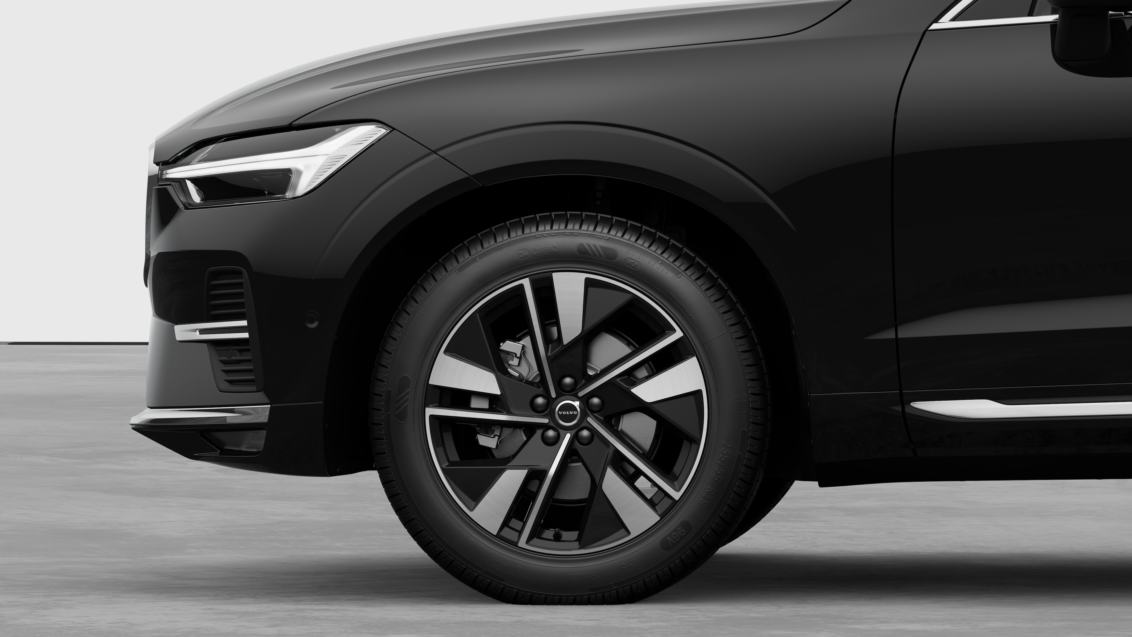 Volvo car exterior side view focusing on the front wheel and fender, set against a plain studio background.