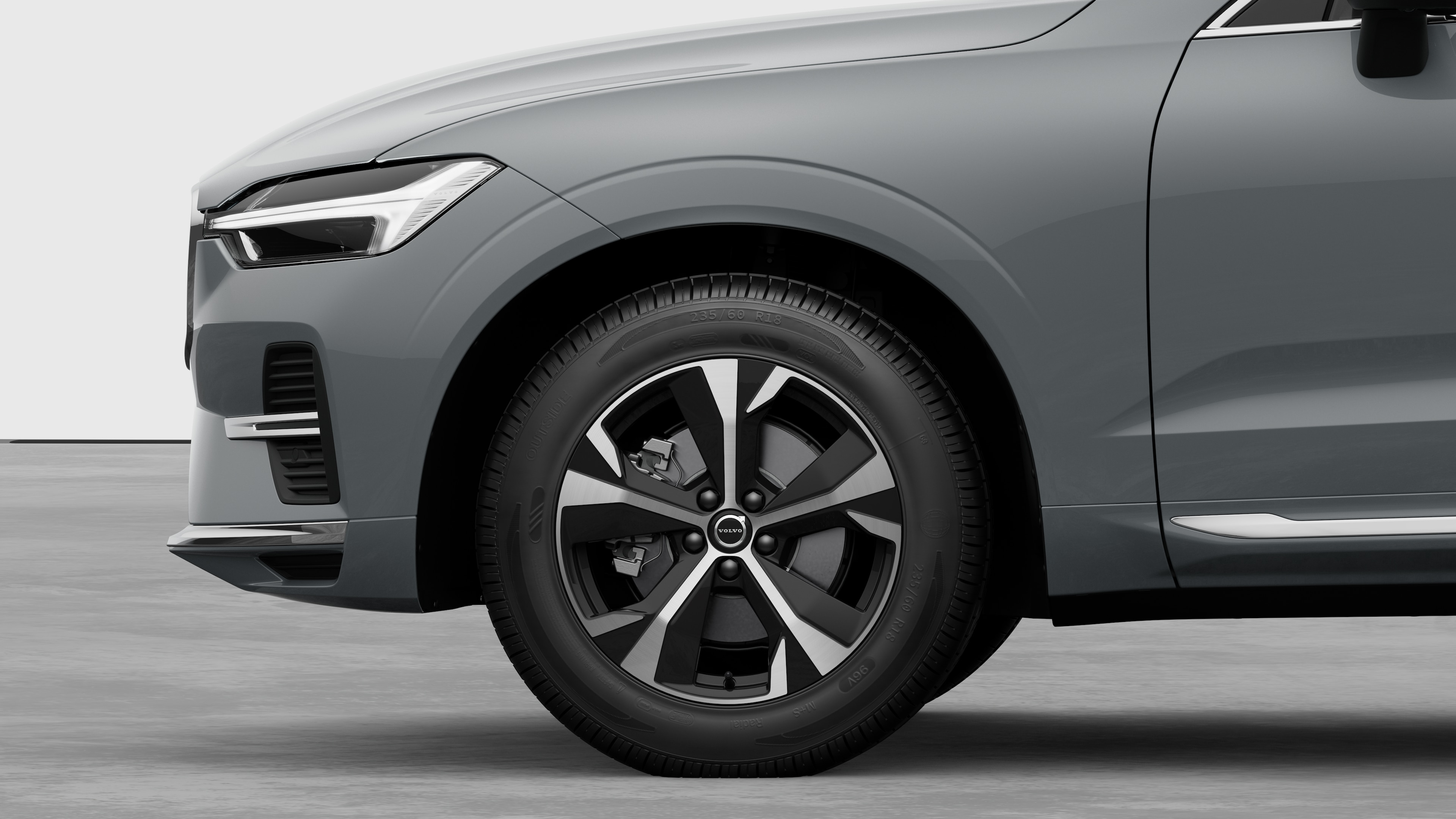 Volvo car exterior side view focusing on the front wheel and fender, set against a plain studio background.