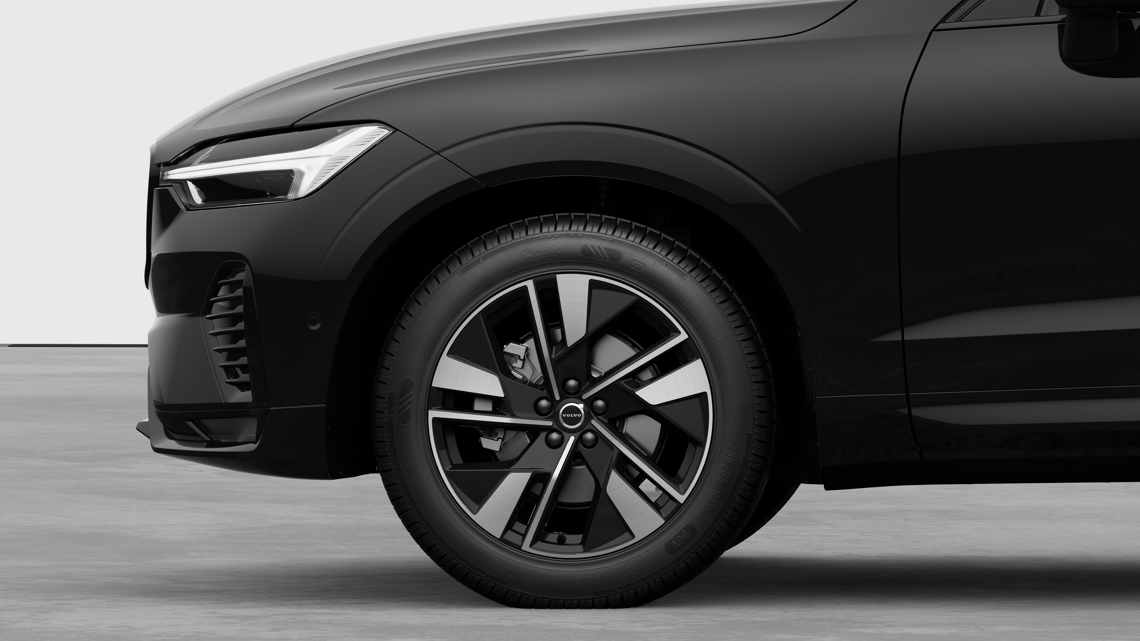 Volvo car exterior side view focusing on the front wheel and fender, set against a plain studio background.
