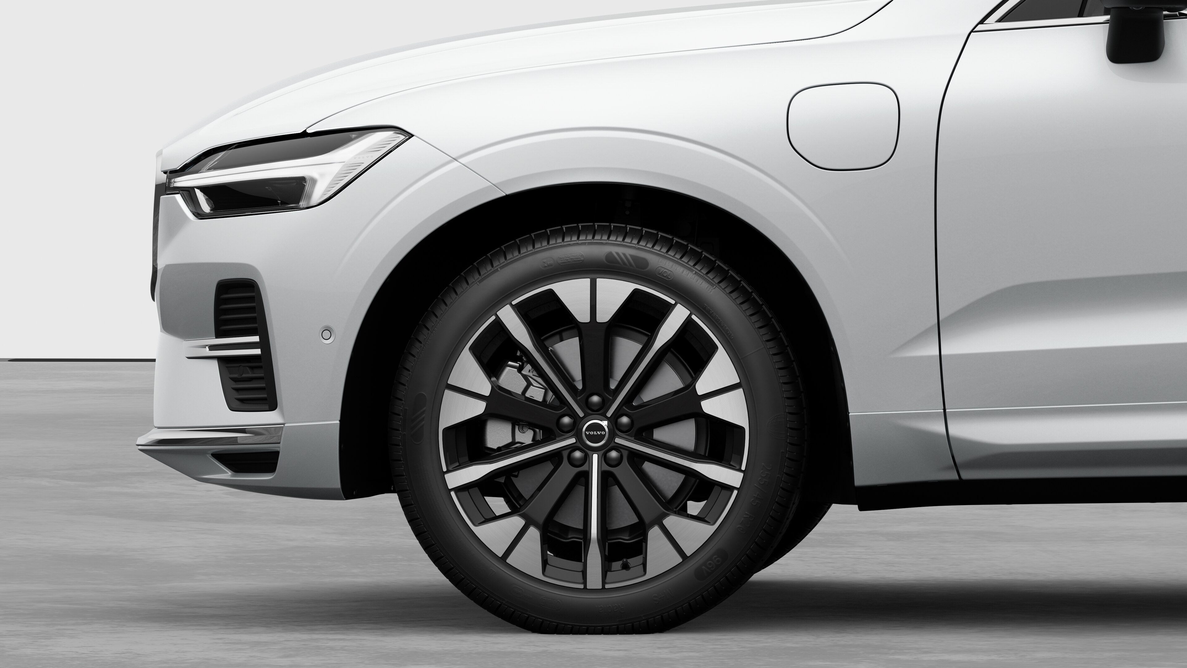 평범한 스튜디오 배경을 배경으로 앞바퀴와 펜더에 초점을 맞춘 볼보 자동차 외부 측면도.