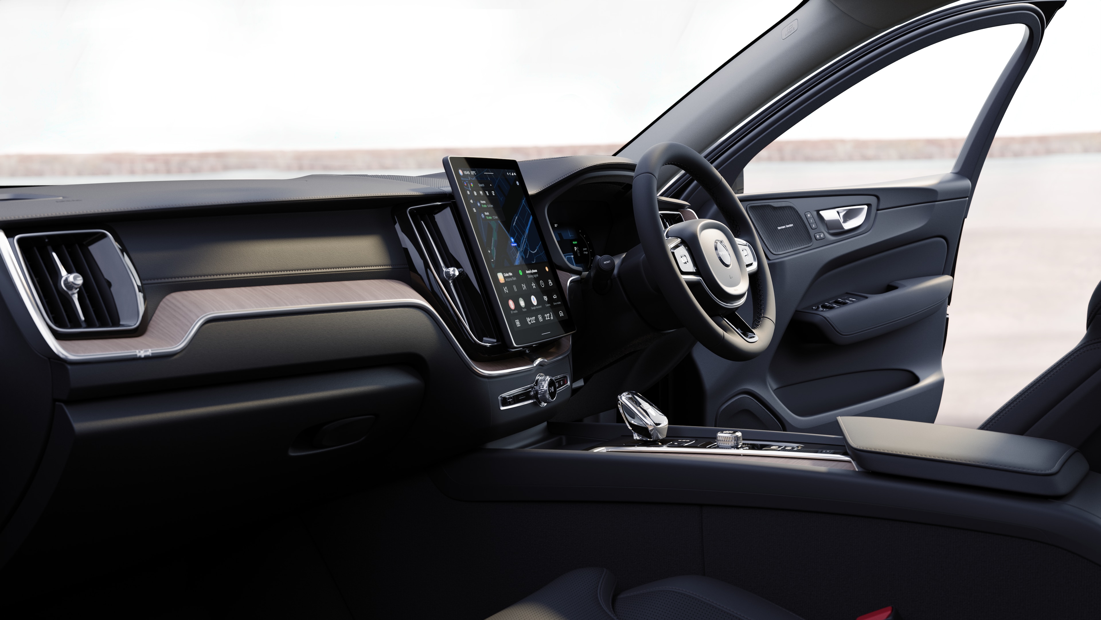 Volvo car interior showing dashboard, steering wheel, and center console with digital display in an open road background.