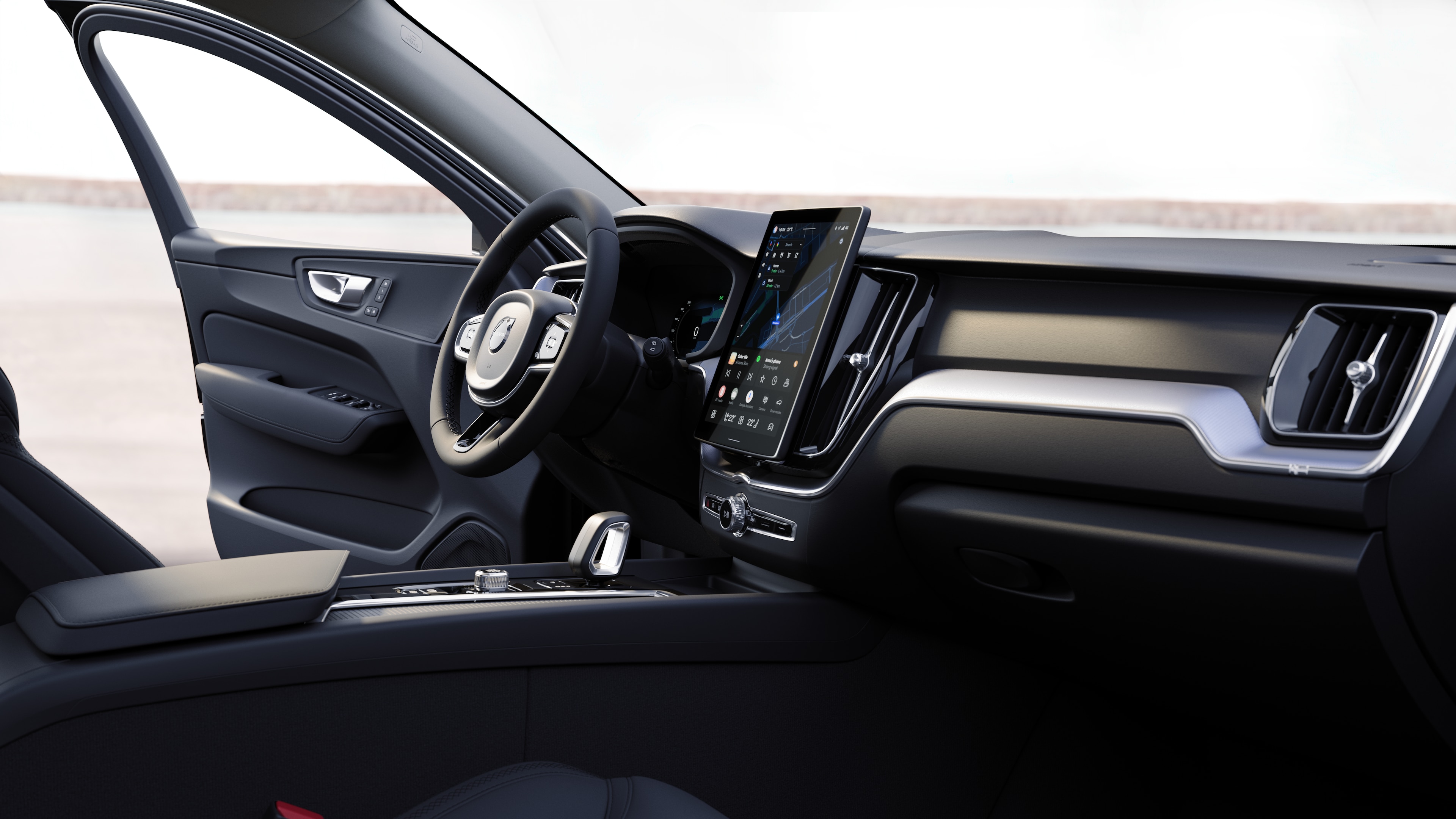 Interior del vehículo Volvo que muestra el salpicadero, el volante y la consola central con pantalla digital en un fondo de carretera abierta.