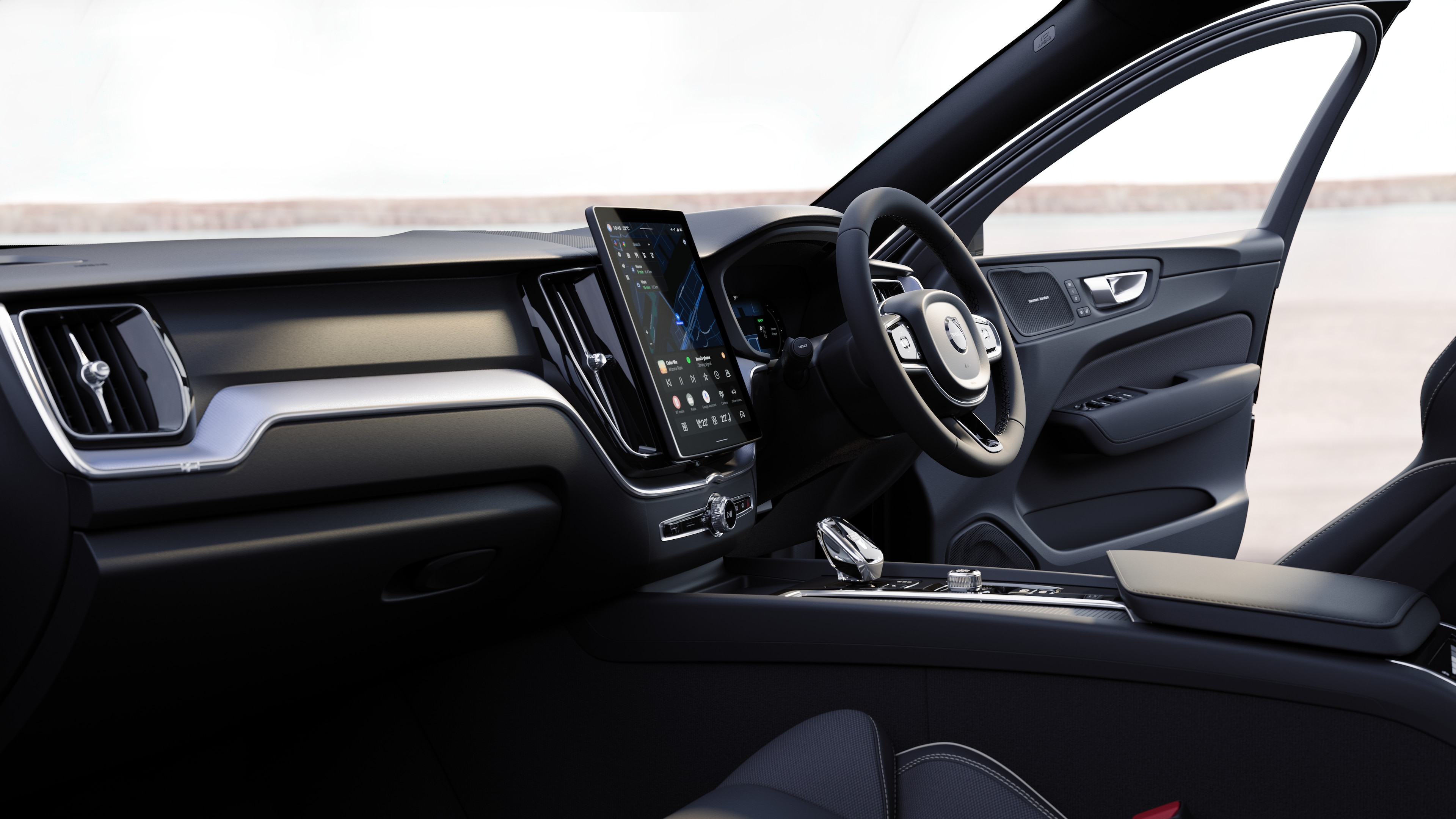 Volvo car interior showing dashboard, steering wheel, and center console with digital display in an open road background.