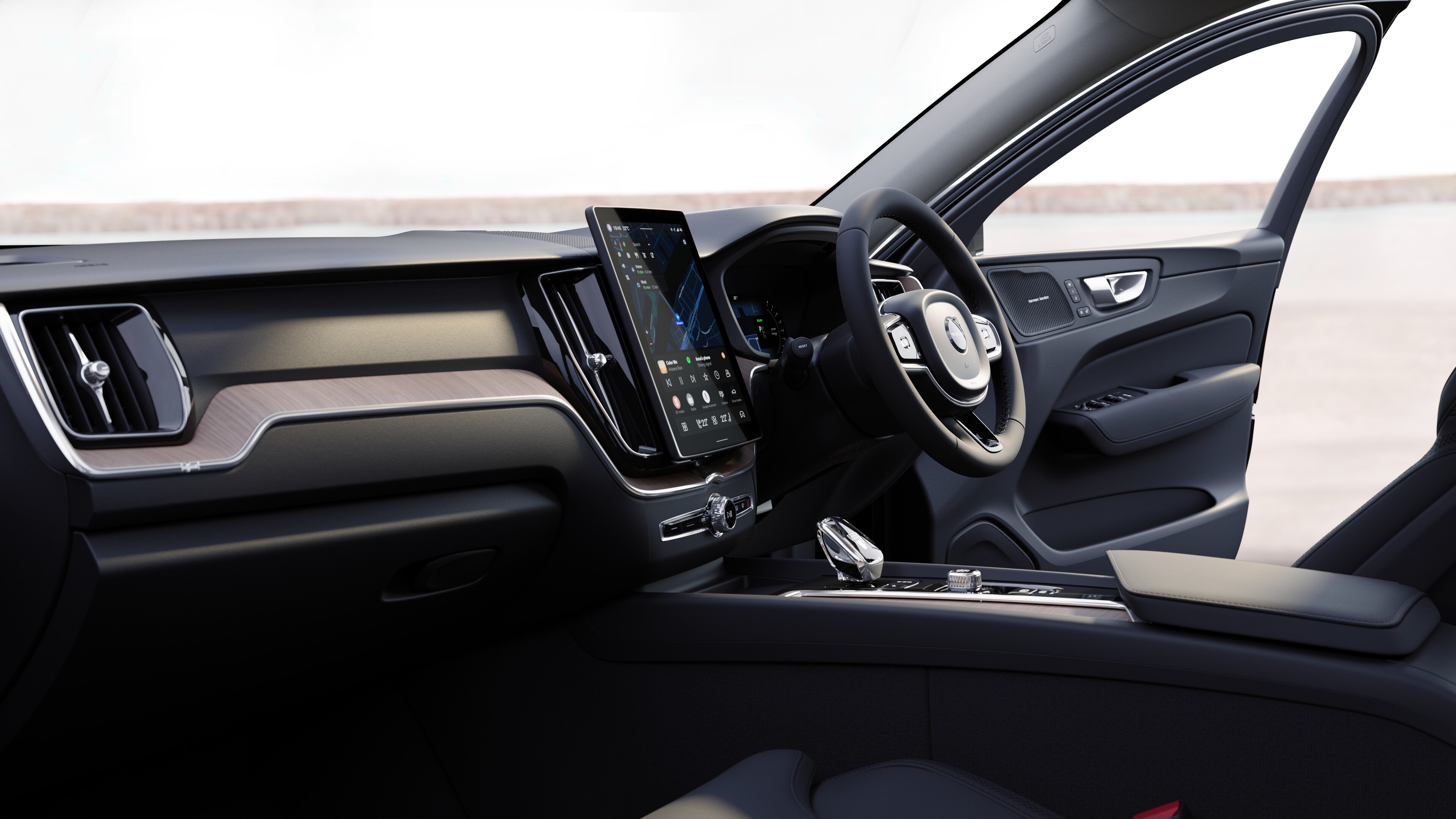 Volvo car interior showing dashboard, steering wheel, and center console with digital display in an open road background.