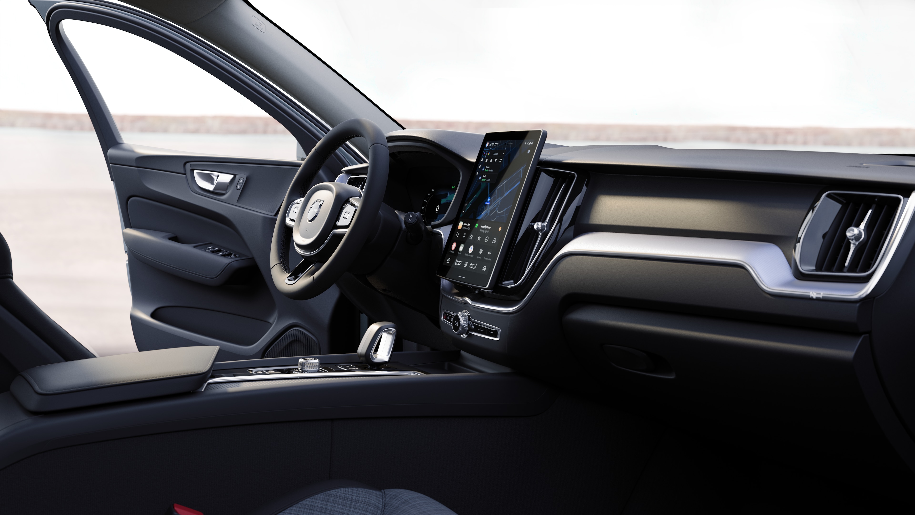 Unutrašnjost automobila Volvo prikazuje nadzornu ploču, upravljač i središnju konzolu s digitalnim zaslonom u otvorenoj pozadini ceste.
