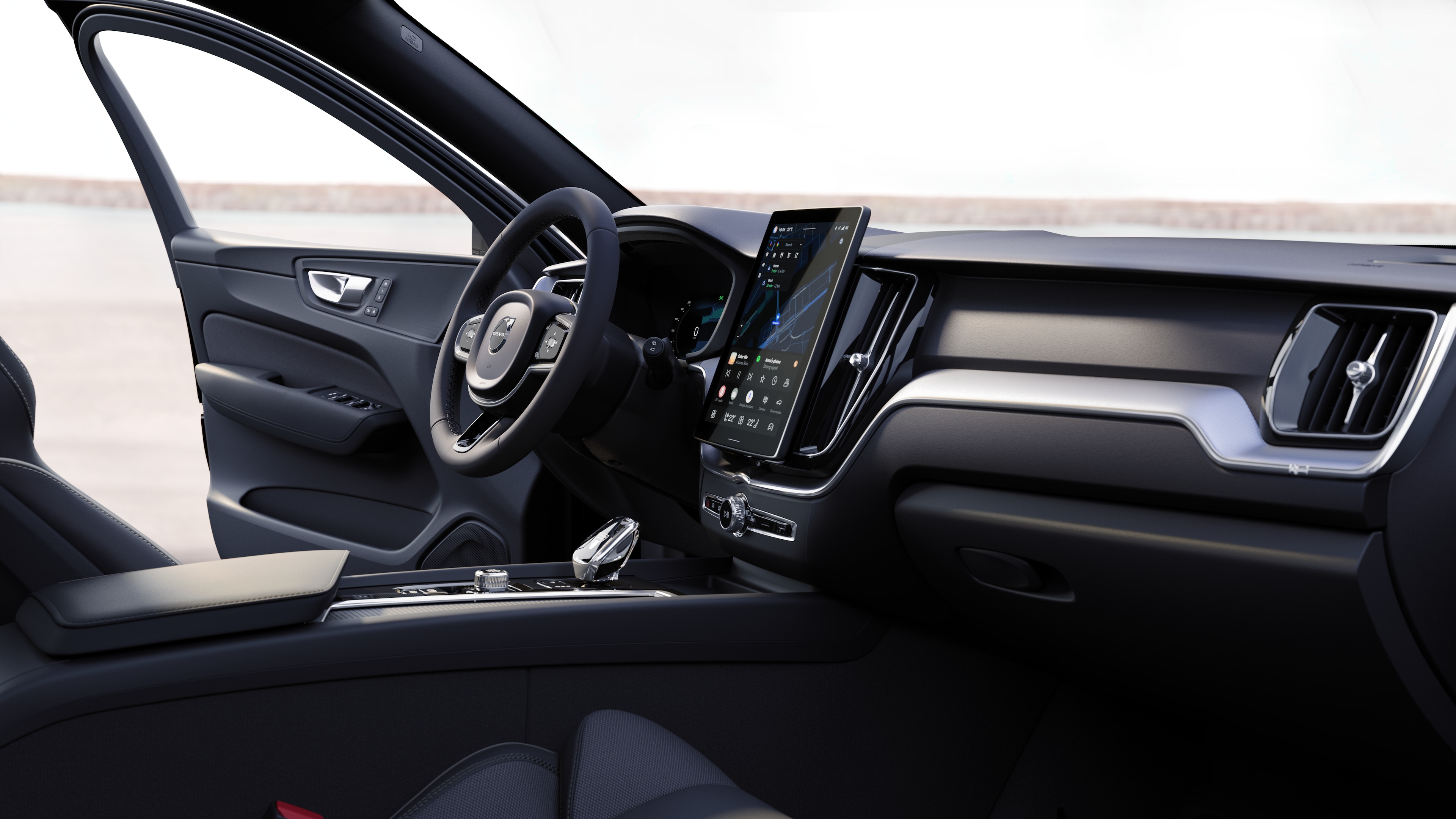 Interiør i en Volvo med dashbord, ratt og midtkonsoll med digitalt display i åpen veibakgrunn.