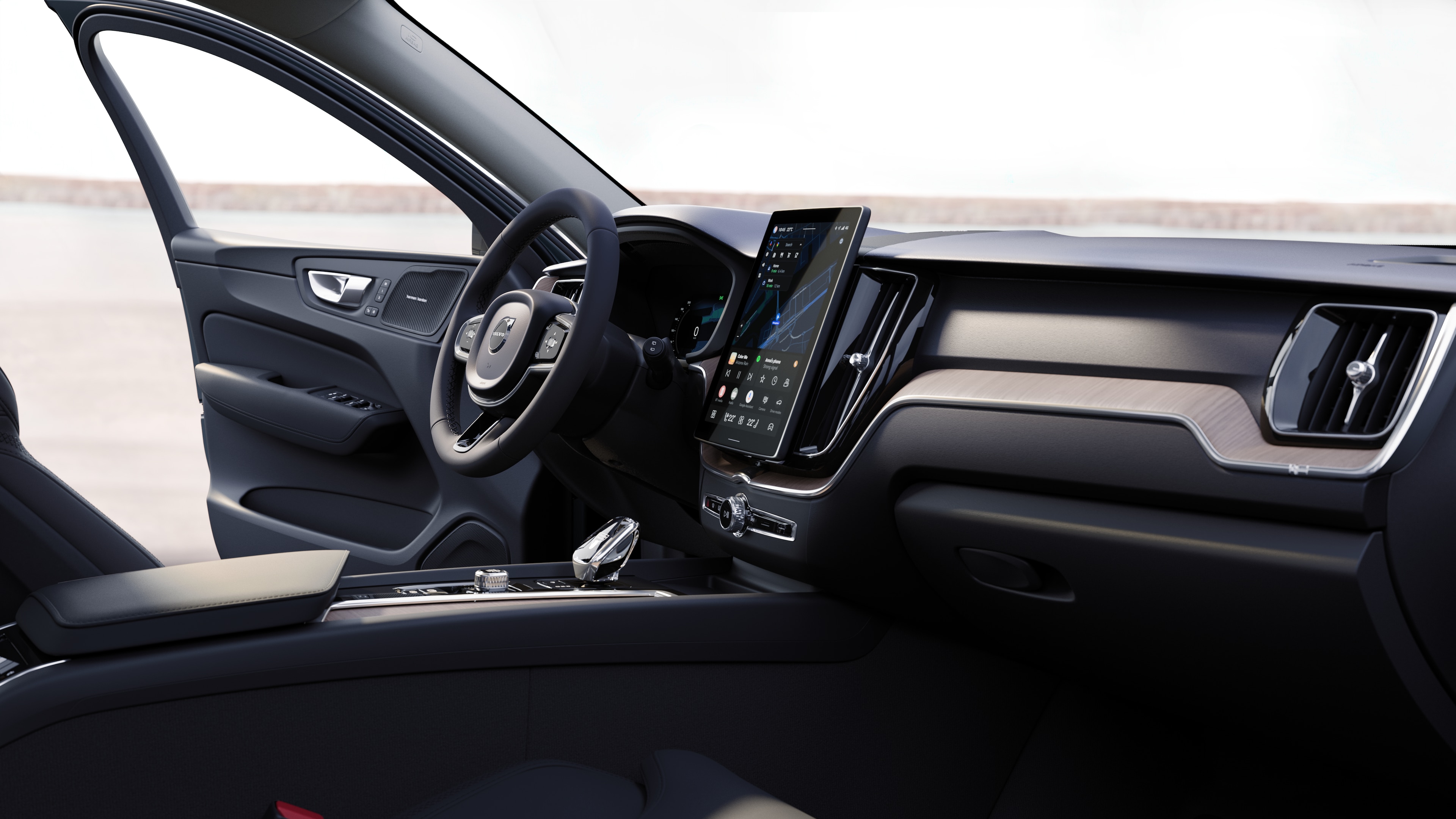 Innenraum eines Volvo mit Armaturenbrett, Lenkrad und Mittelkonsole mit Digitalanzeige vor dem Hintergrund der offenen Straße.
