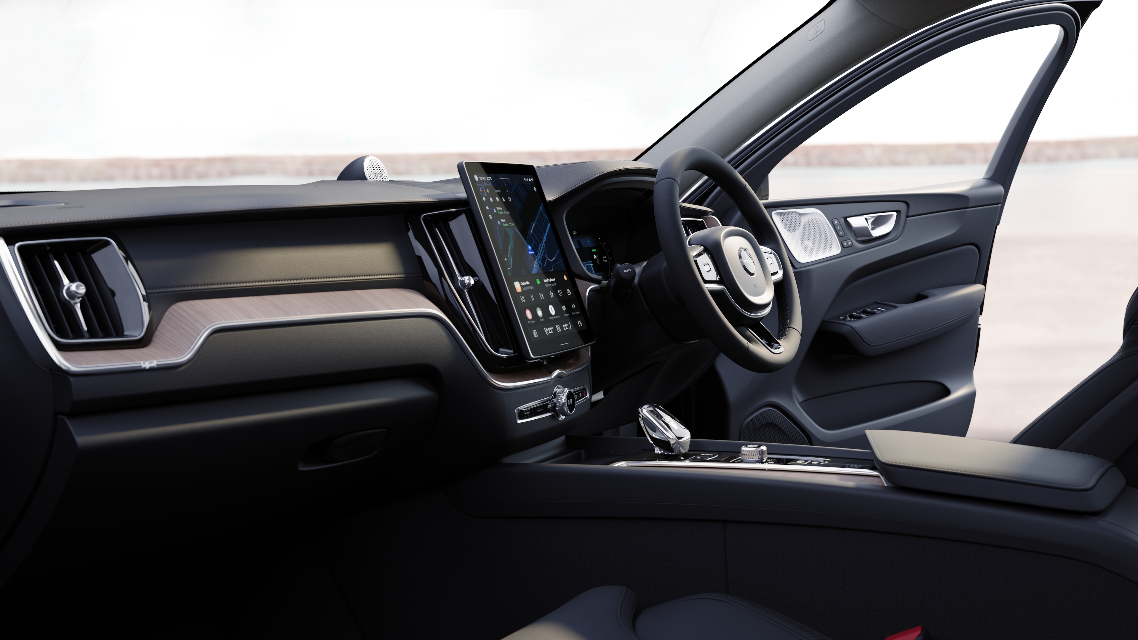 Volvo car interior showing dashboard, steering wheel, and center console with digital display in an open road background.