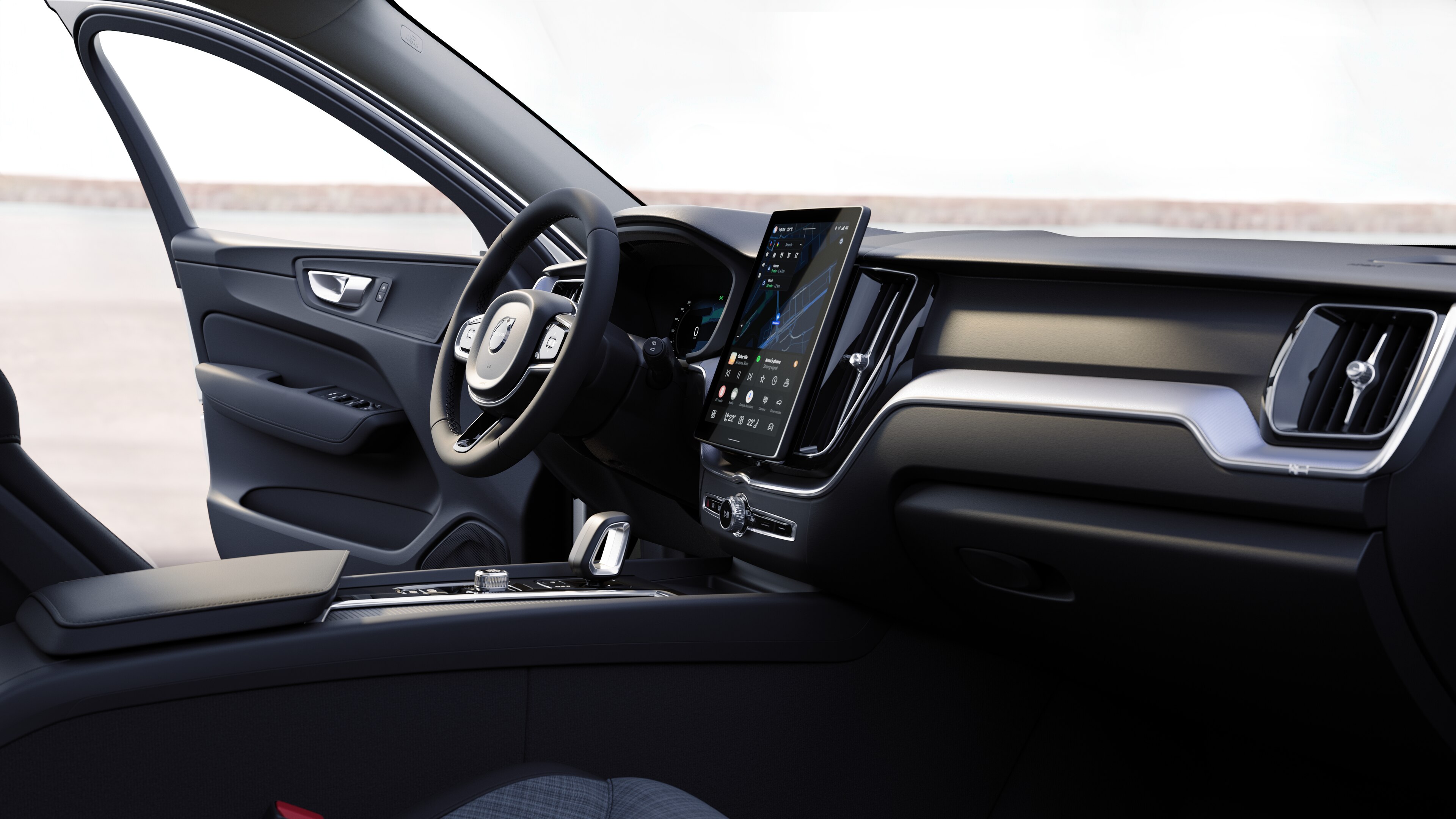 Interno di un'auto Volvo che mostra cruscotto, volante e console centrale con display digitale sullo sfondo di una strada aperta.