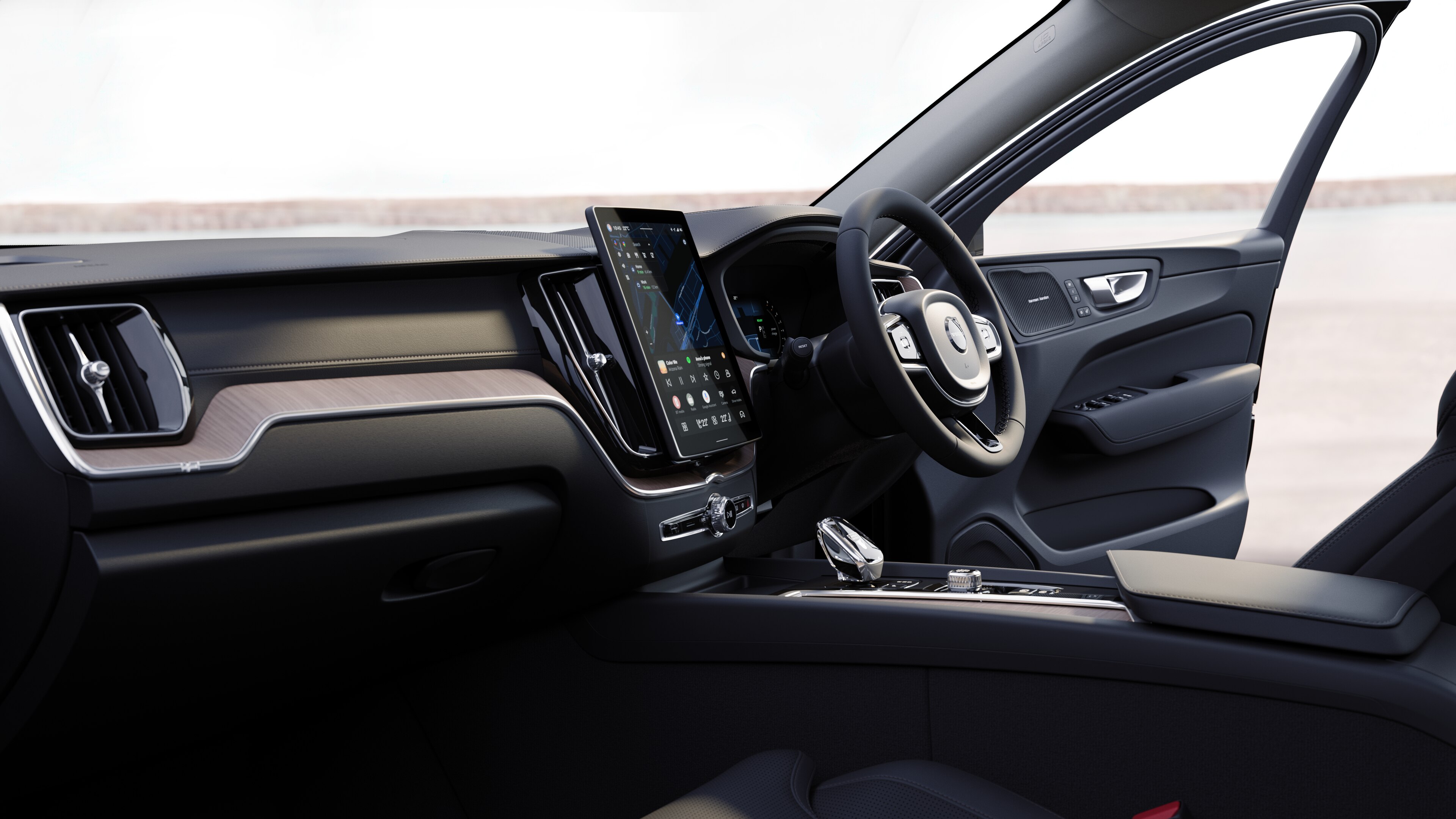 Volvo car interior showing dashboard, steering wheel, and center console with digital display in an open road background.