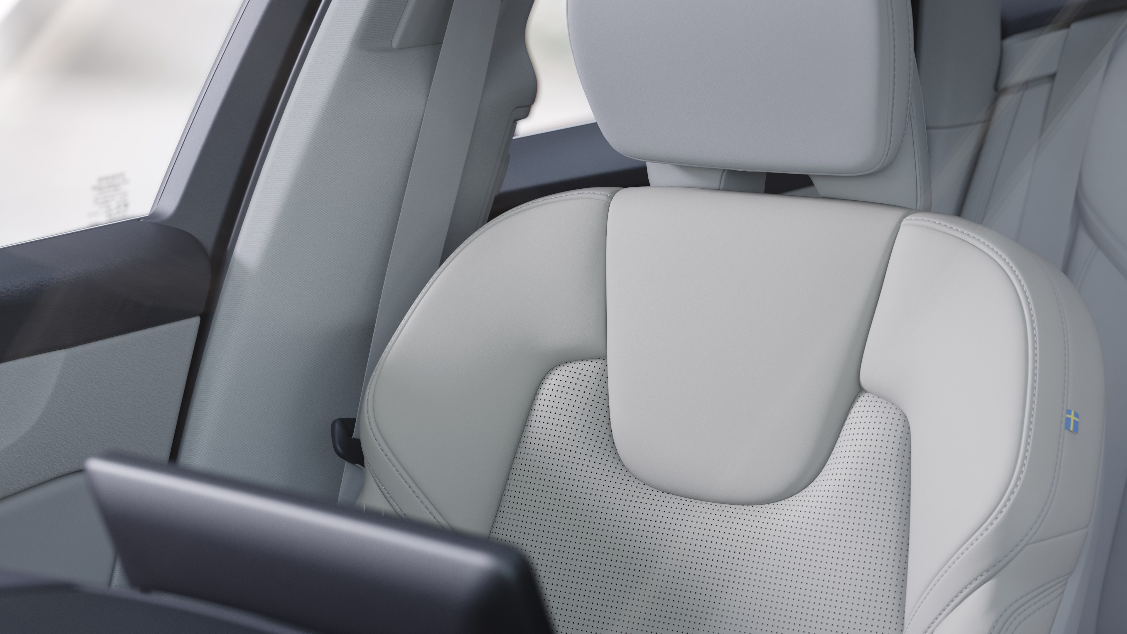 평범한 스튜디오 배경에 앞좌석 및 뒷좌석 조수석, 스티어링 휠, 대시보드 및 센터 콘솔을 보여주는 볼보 자동차 내부.