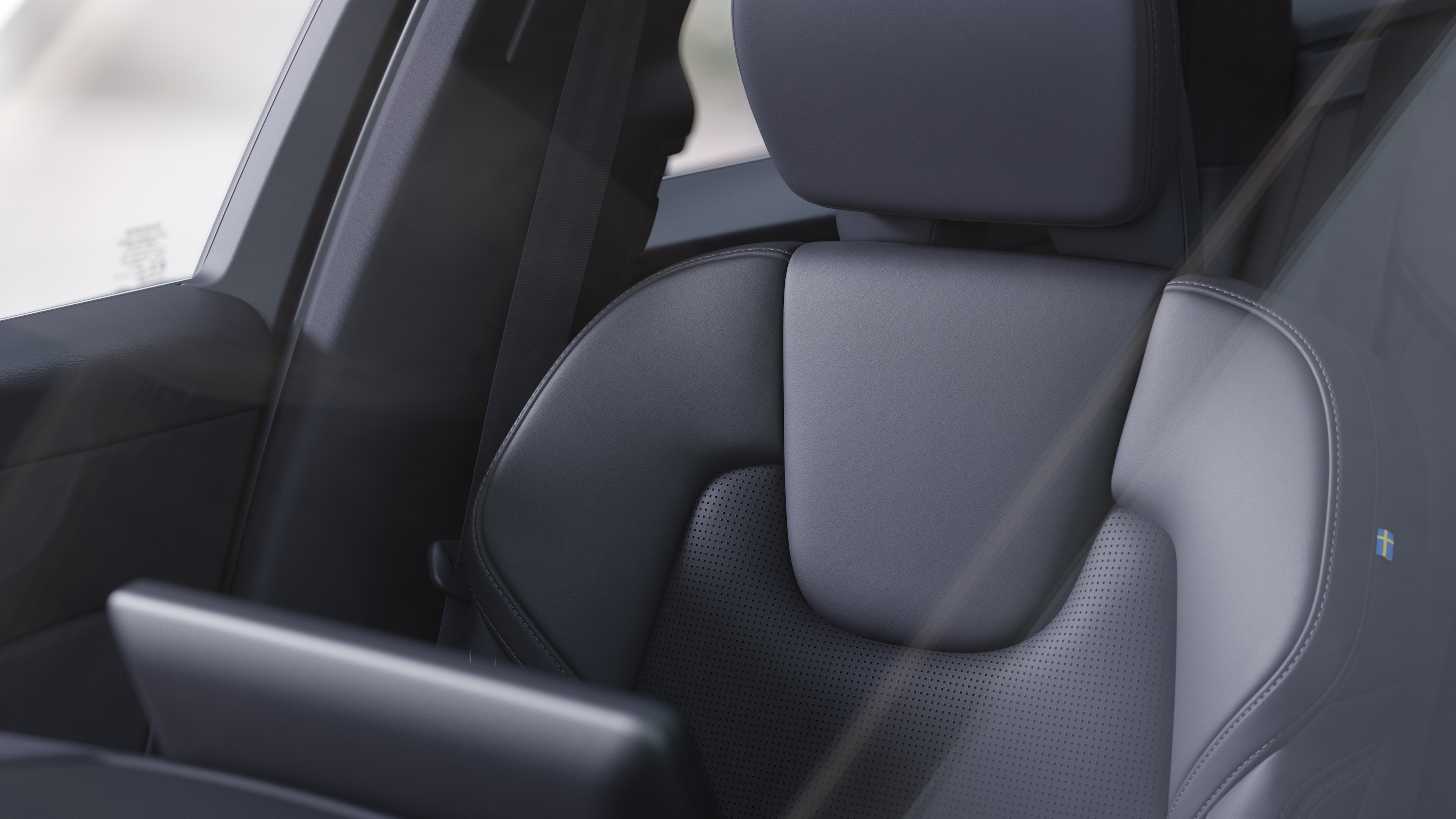 Innenraum eines Volvo mit Beifahrer- und Rücksitzen, Lenkrad, Armaturenbrett und Mittelkonsole vor einem schlichten Studiohintergrund.