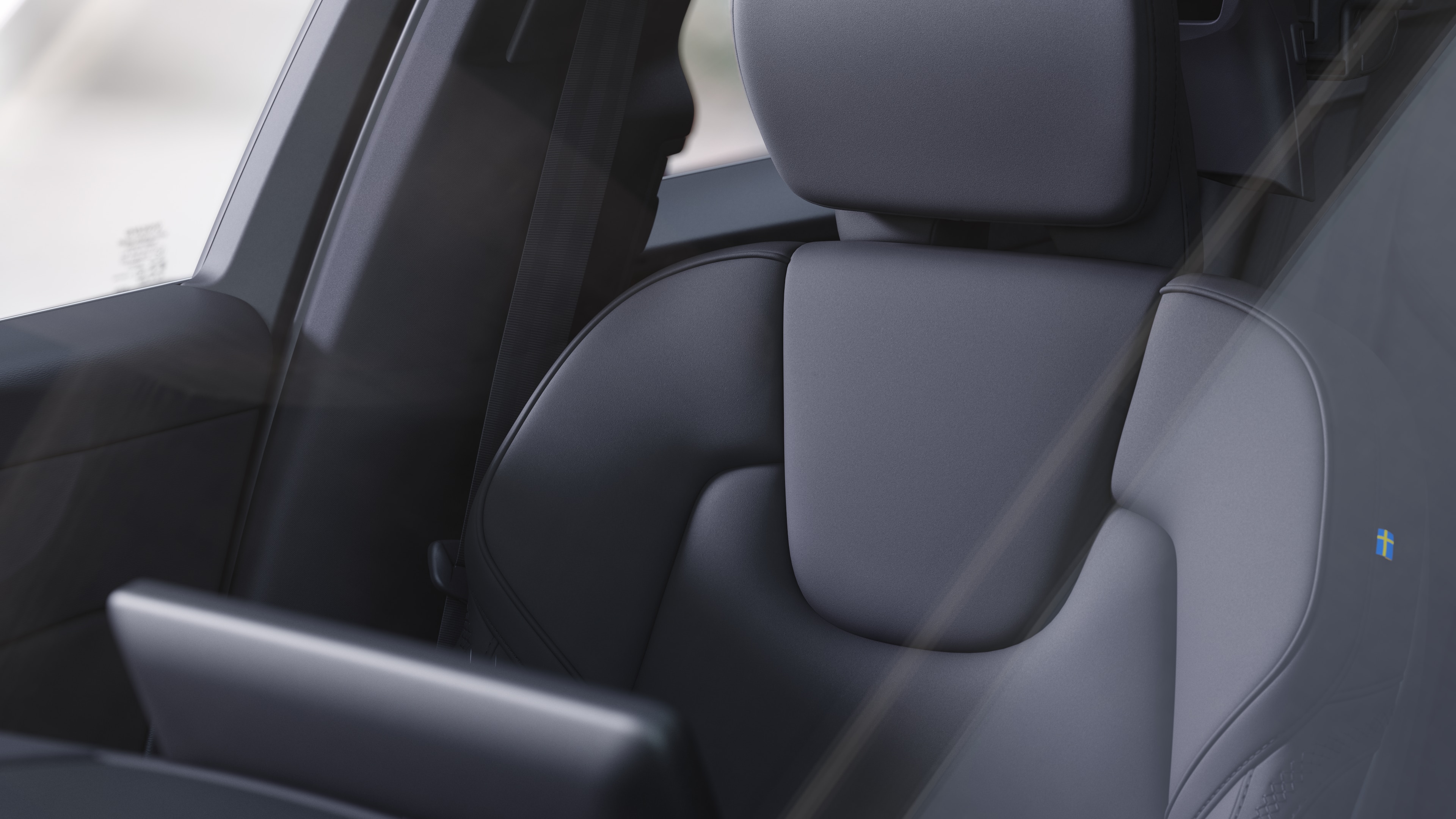 Volvo car interior showing front and rear passenger seats, steering wheel, dashboard, and center console against a plain studio background.