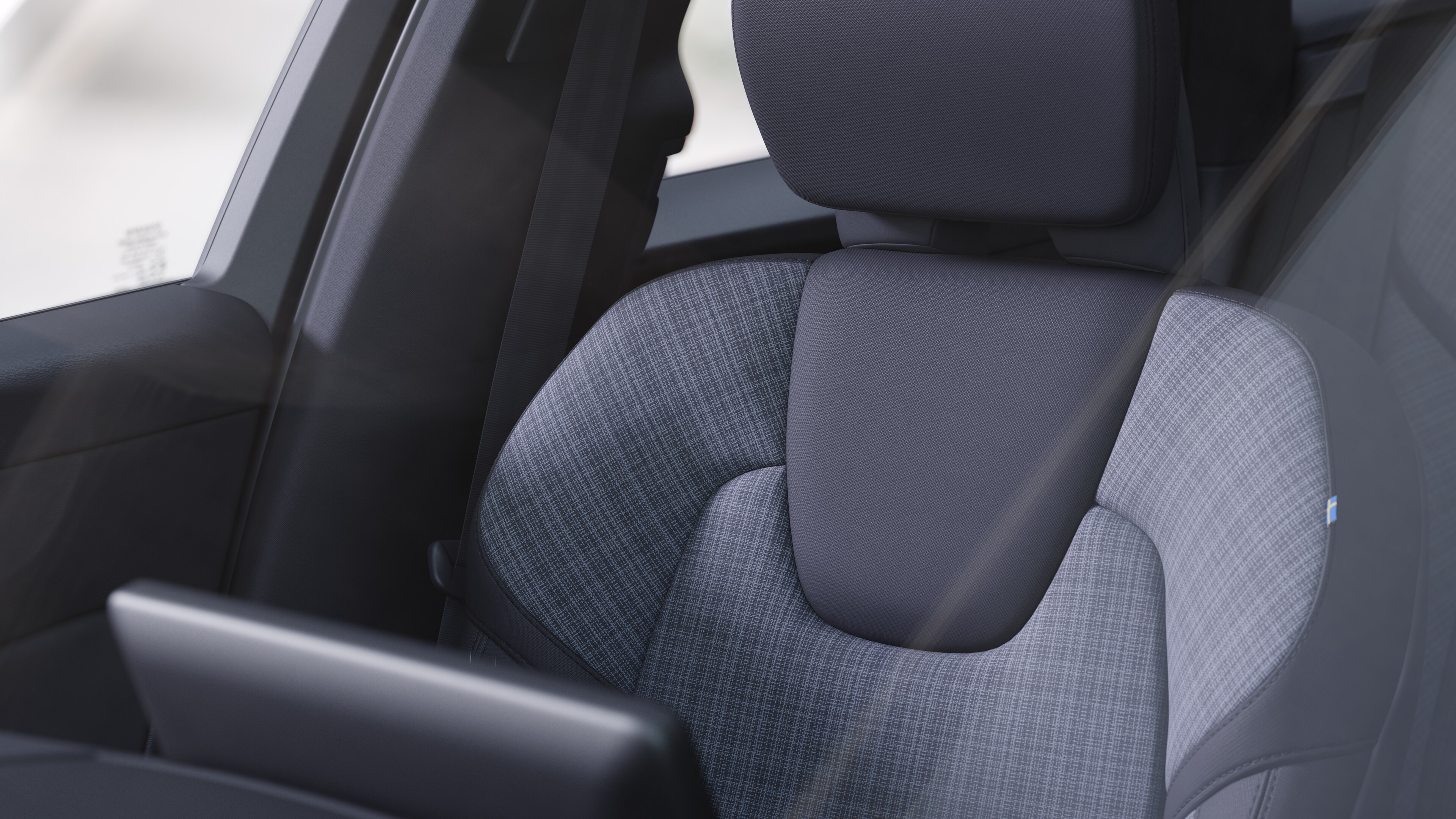 Innenraum eines Volvo mit Beifahrer- und Rücksitzen, Lenkrad, Armaturenbrett und Mittelkonsole vor einem schlichten Studiohintergrund.