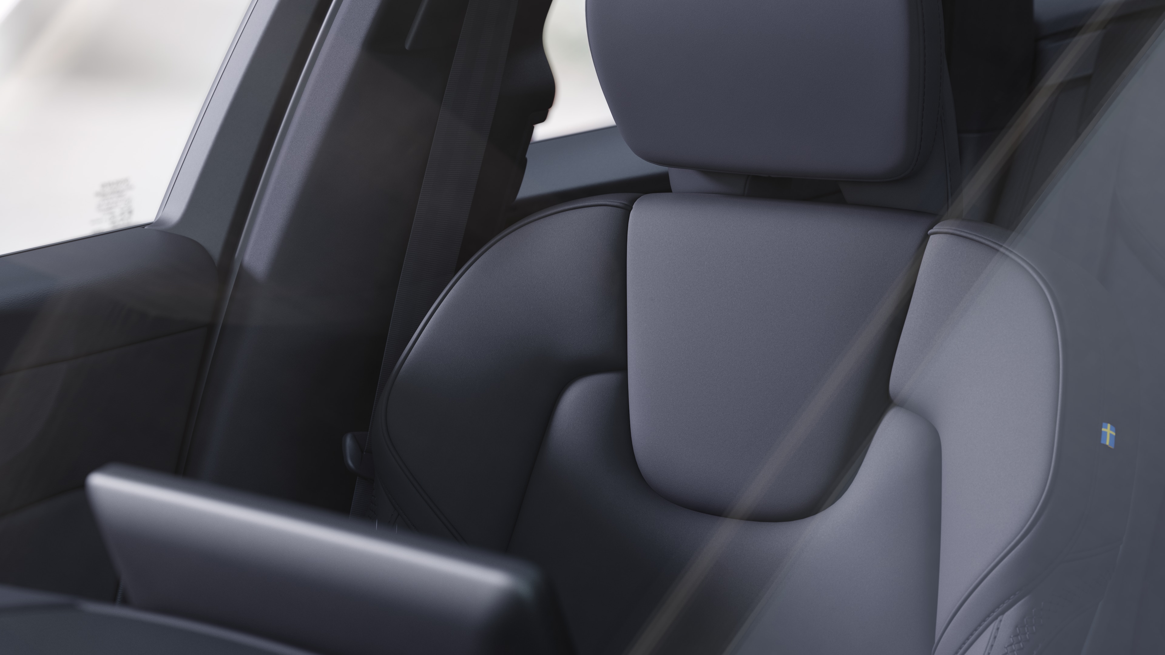 Volvo automašīnas salons ar priekšējiem un aizmugurējiem pasažieru sēdekļiem, stūri, instrumentu paneli un centrālo konsoli uz vienkārša studijas fona.