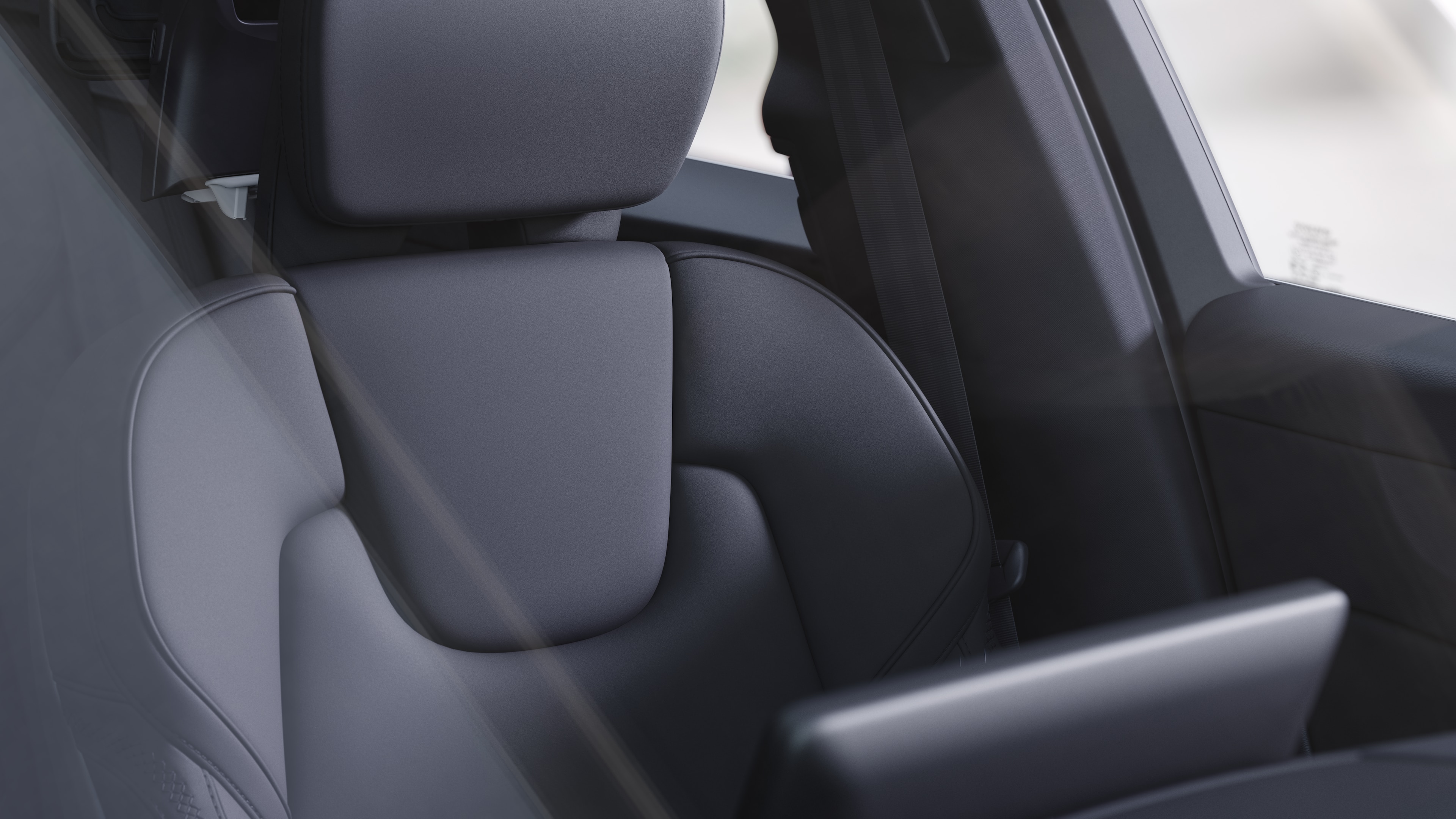 Volvo car interior showing front and rear passenger seats, steering wheel, dashboard, and centre console against a plain studio background.