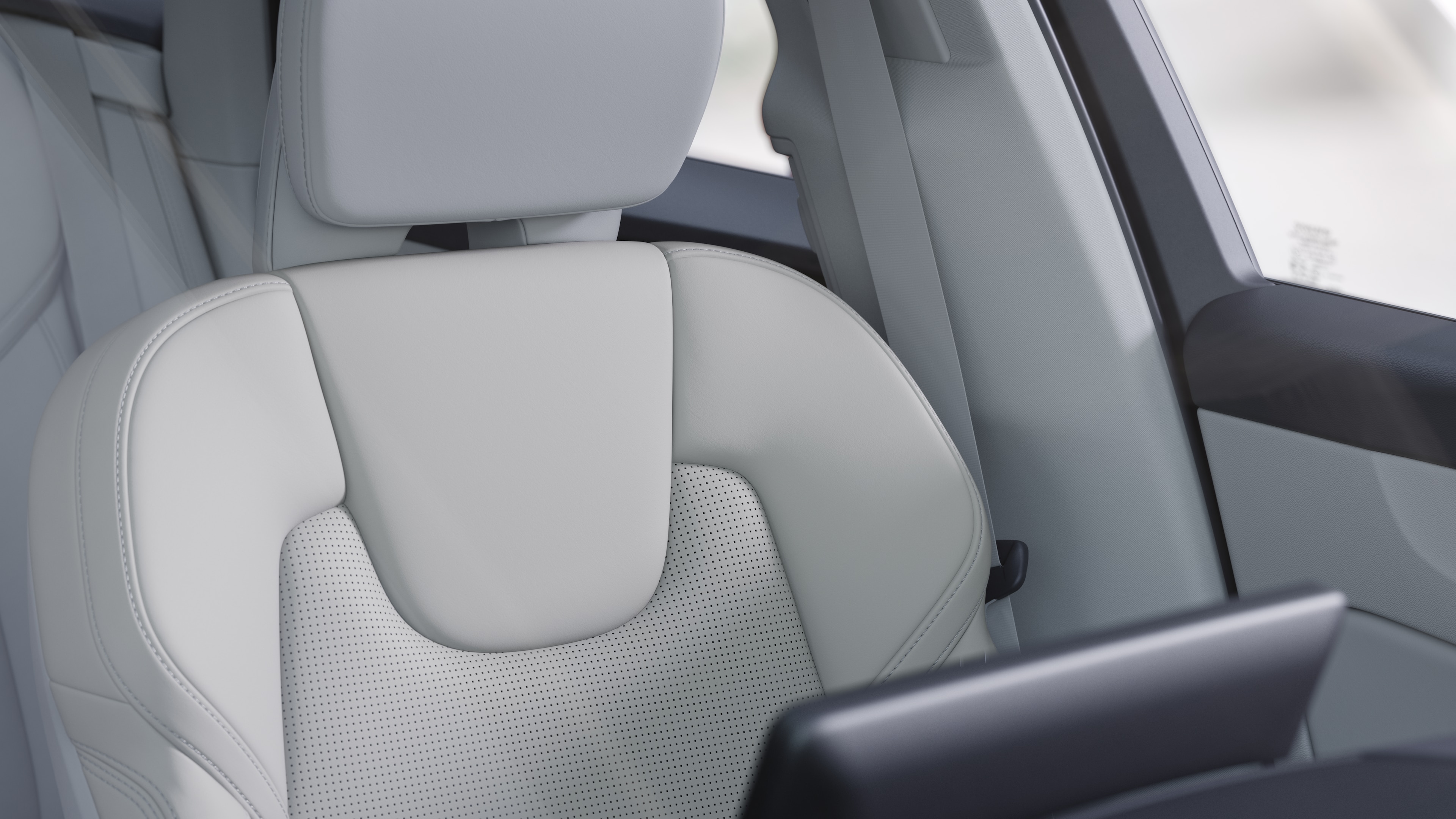 Volvo car interior showing front and rear passenger seats, steering wheel, dashboard, and center console against a plain studio background.