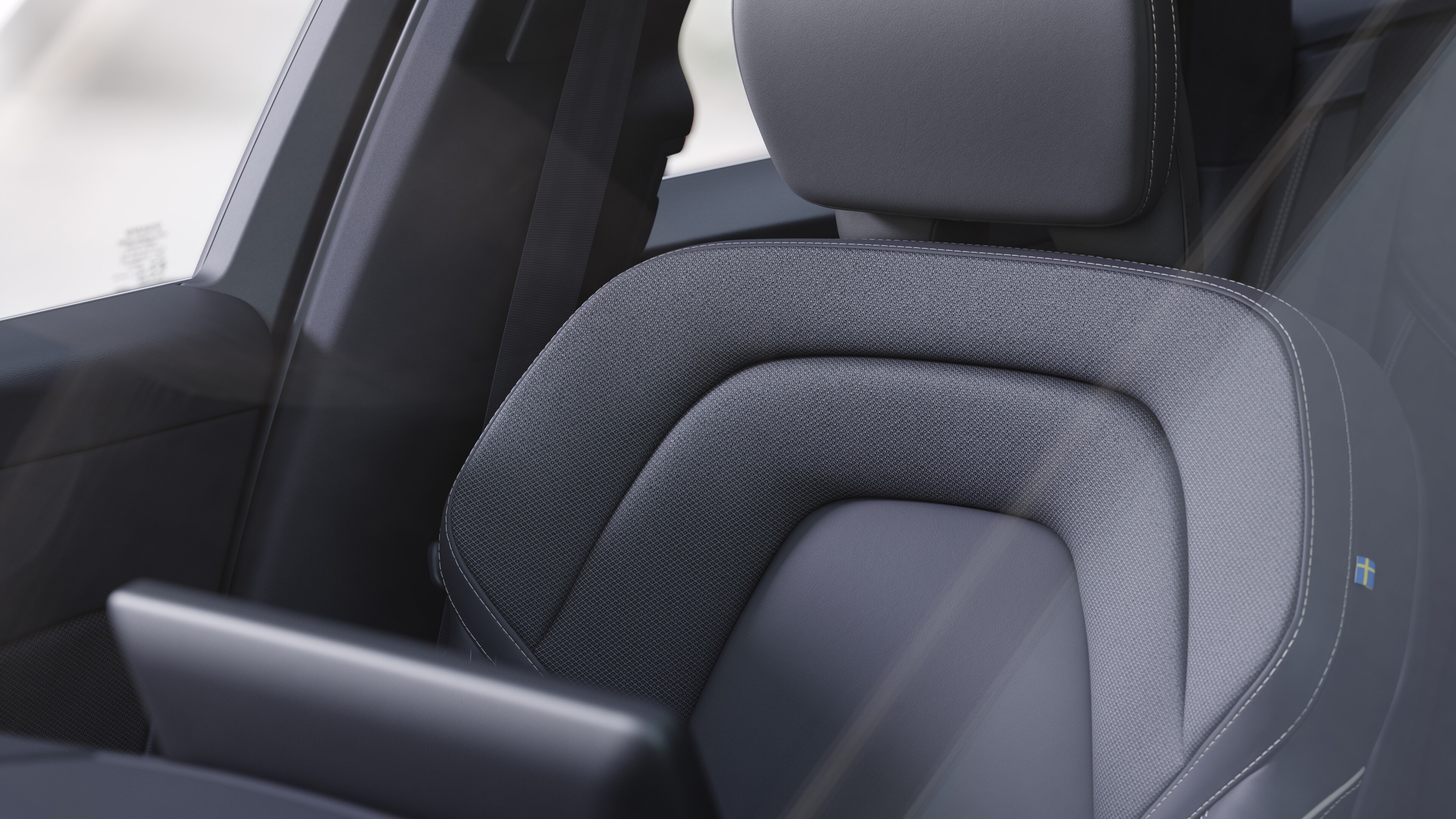 Wnętrze samochodu Volvo z przednimi i tylnymi siedzeniami pasażerów, kierownicą, deską rozdzielczą i konsolą środkową na tle zwykłego studia.