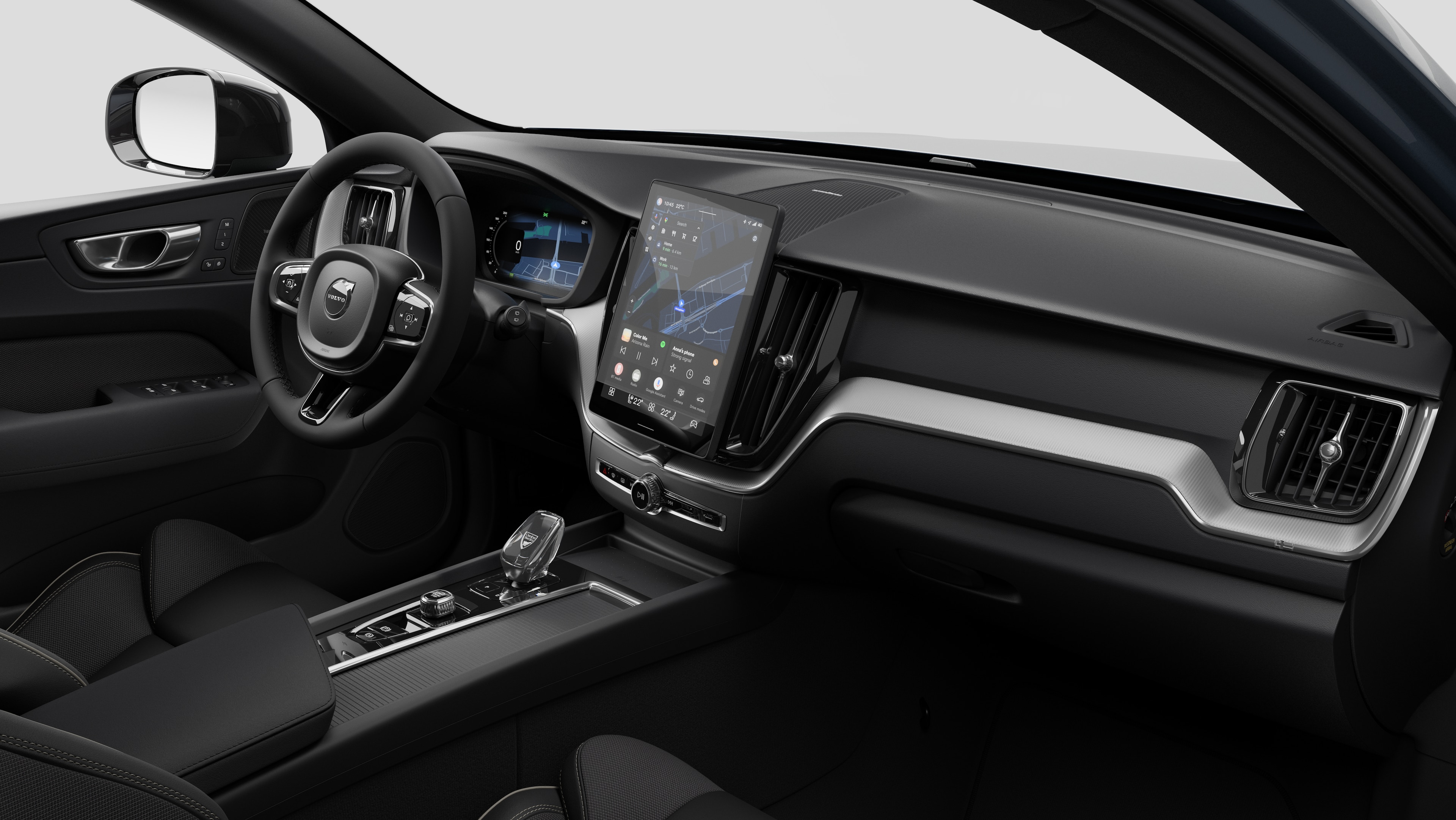Innenansicht eines Volvo mit Armaturenbrett, Lenkrad, Mittelkonsole und digitalem Bildschirm in einem schlichten Studiohintergrund.