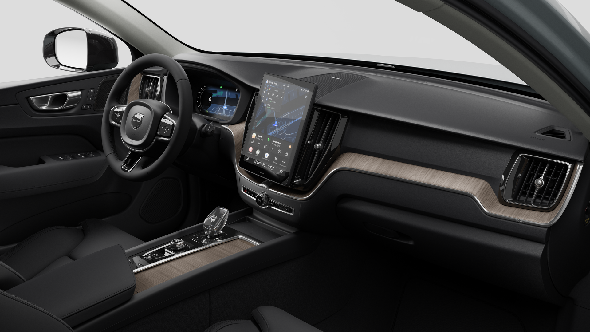 Vue intérieure d’une Volvo montrant le tableau de bord, le volant, la console centrale et l’écran d’affichage numérique sur un fond de studio uni.