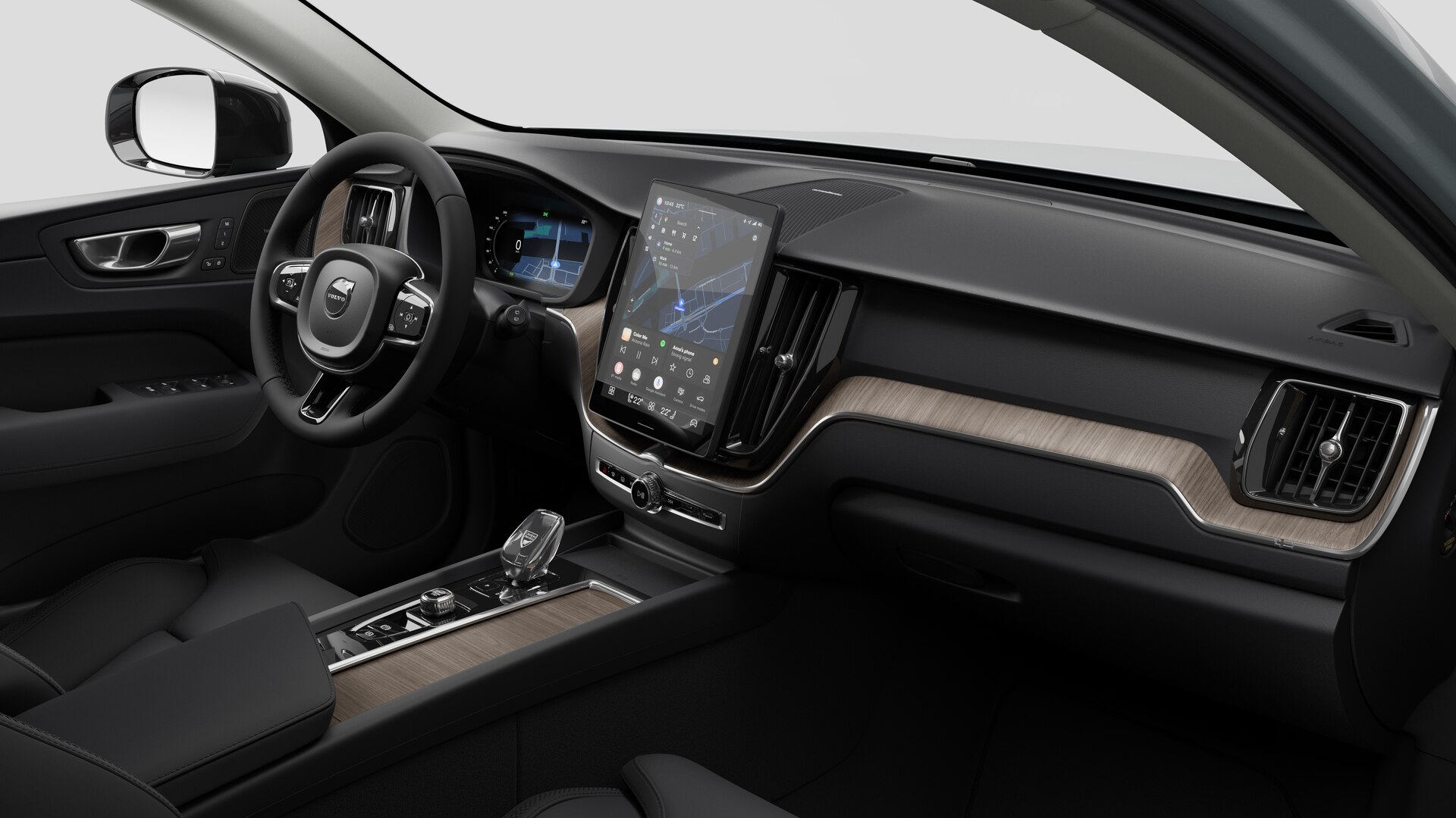 Vue intérieure d’une Volvo montrant le tableau de bord, le volant, la console centrale et l’écran d’affichage numérique sur un fond de studio uni.