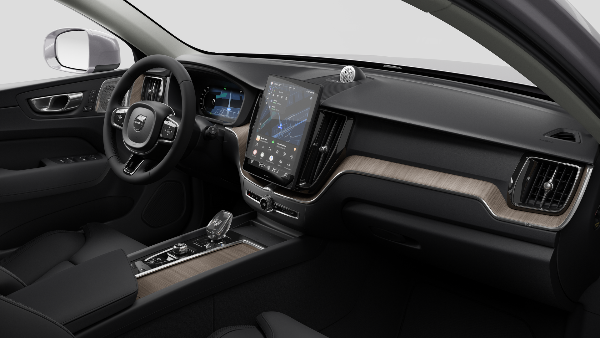 Vue intérieure d’une Volvo montrant le tableau de bord, le volant, la console centrale et l’écran d’affichage numérique sur un fond de studio uni.