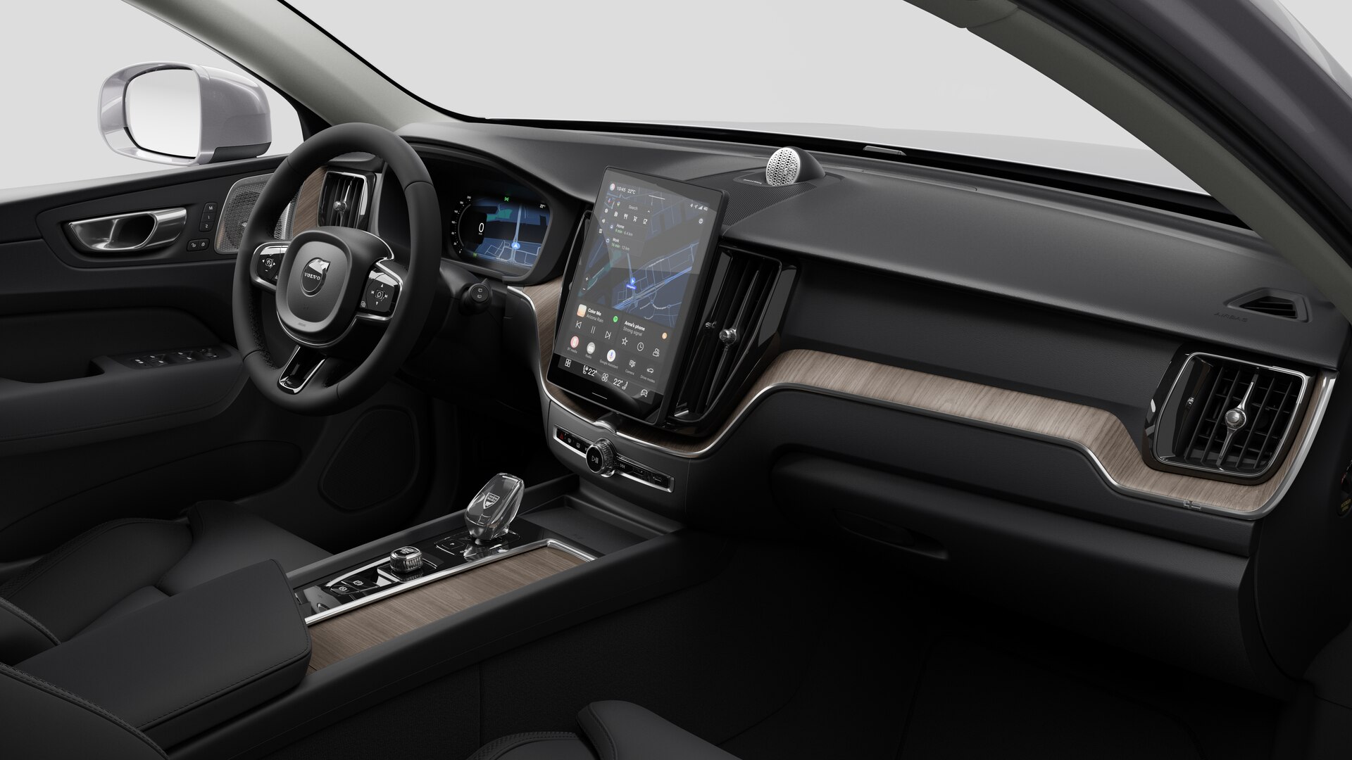 Vue intérieure d’une Volvo montrant le tableau de bord, le volant, la console centrale et l’écran d’affichage numérique sur un fond de studio uni.