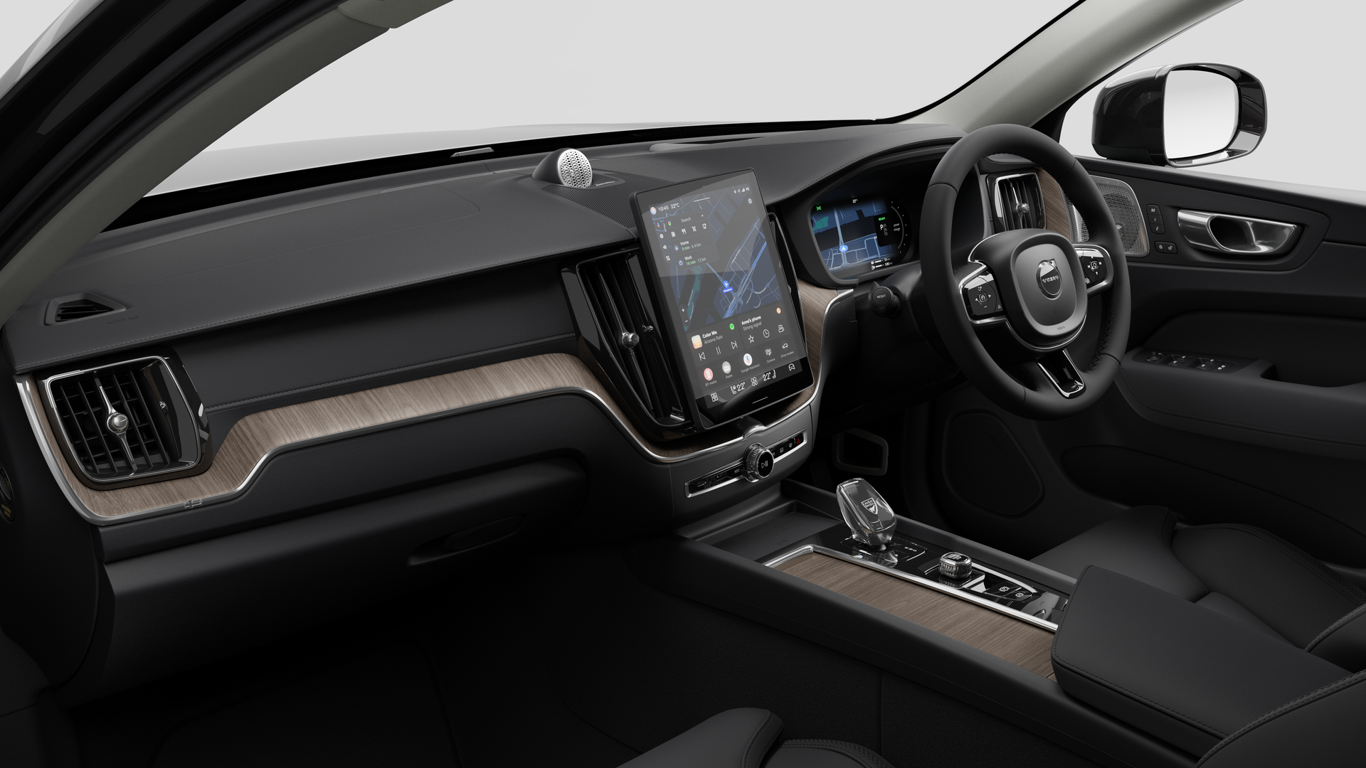 Interior view of a Volvo car showing the dashboard, steering wheel, center console, and digital display screen in a plain studio background.