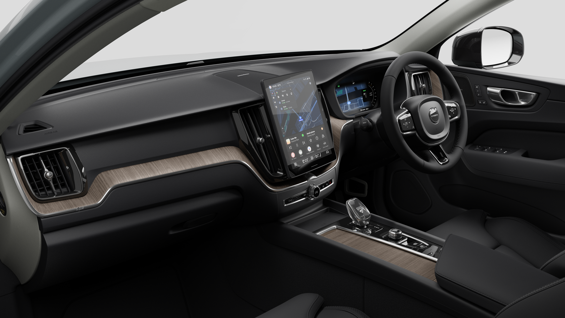 Interior view of a Volvo car showing the dashboard, steering wheel, center console, and digital display screen in a plain studio background.